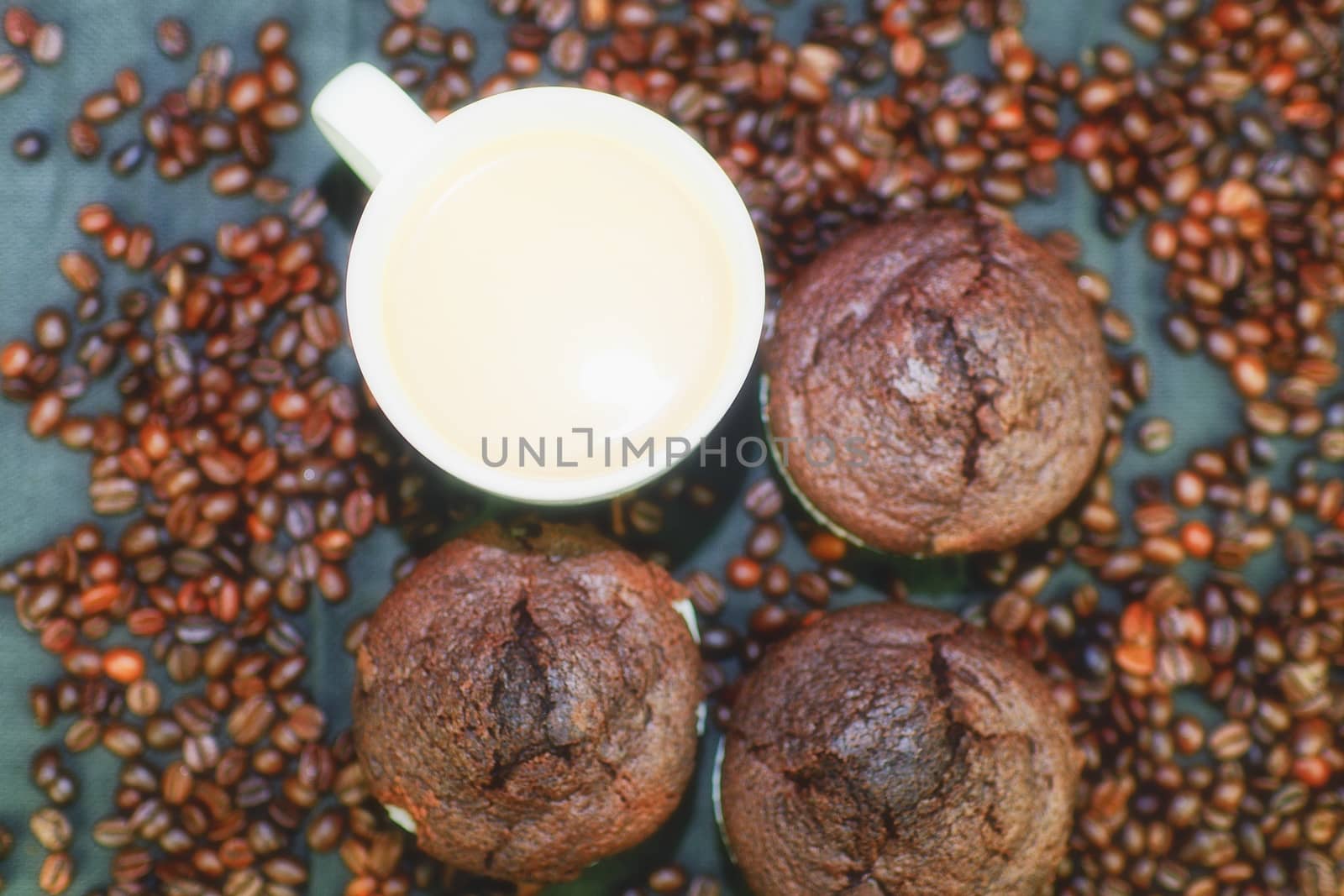 Dark muffins, cups of coffee and coffee beans on black background. Flat design. Coffee bar concept.
