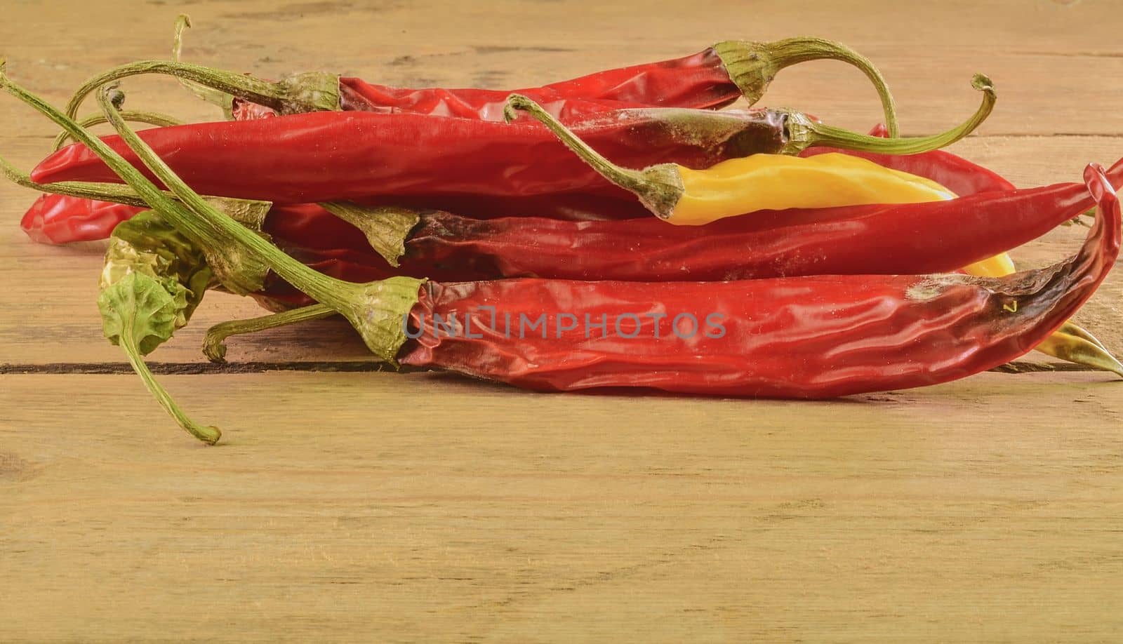 Shrinking and mould chili peppers on white wooden background. Rotten chili peppers by roman_nerud