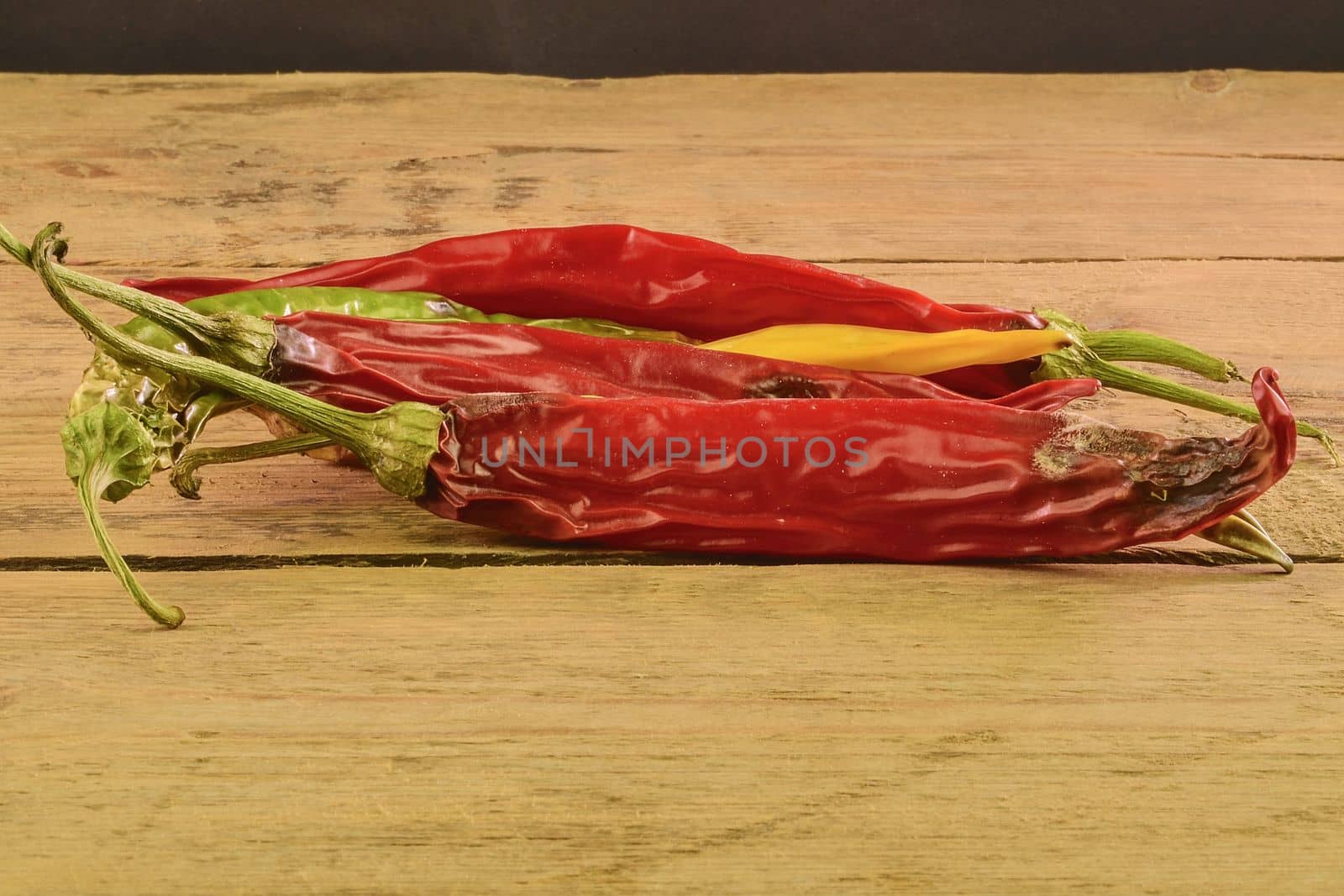 Shrinking and mould chili peppers on white wooden background. Rotten chili peppers by roman_nerud