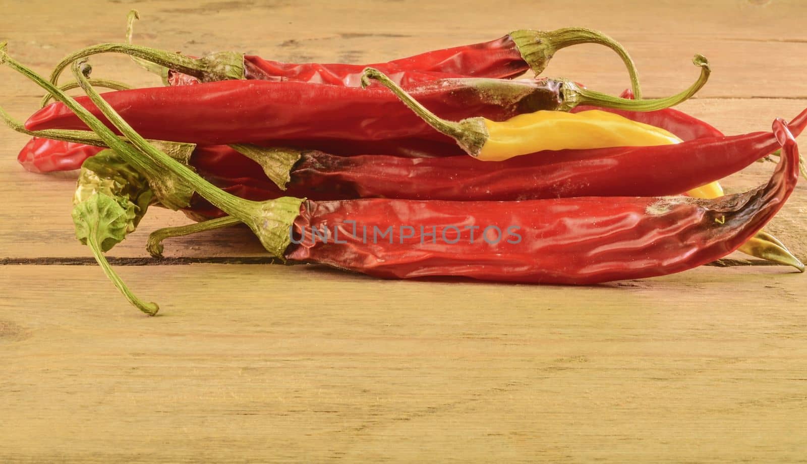 Shrinking and mould chili peppers on white wooden background. Rotten chili peppers.