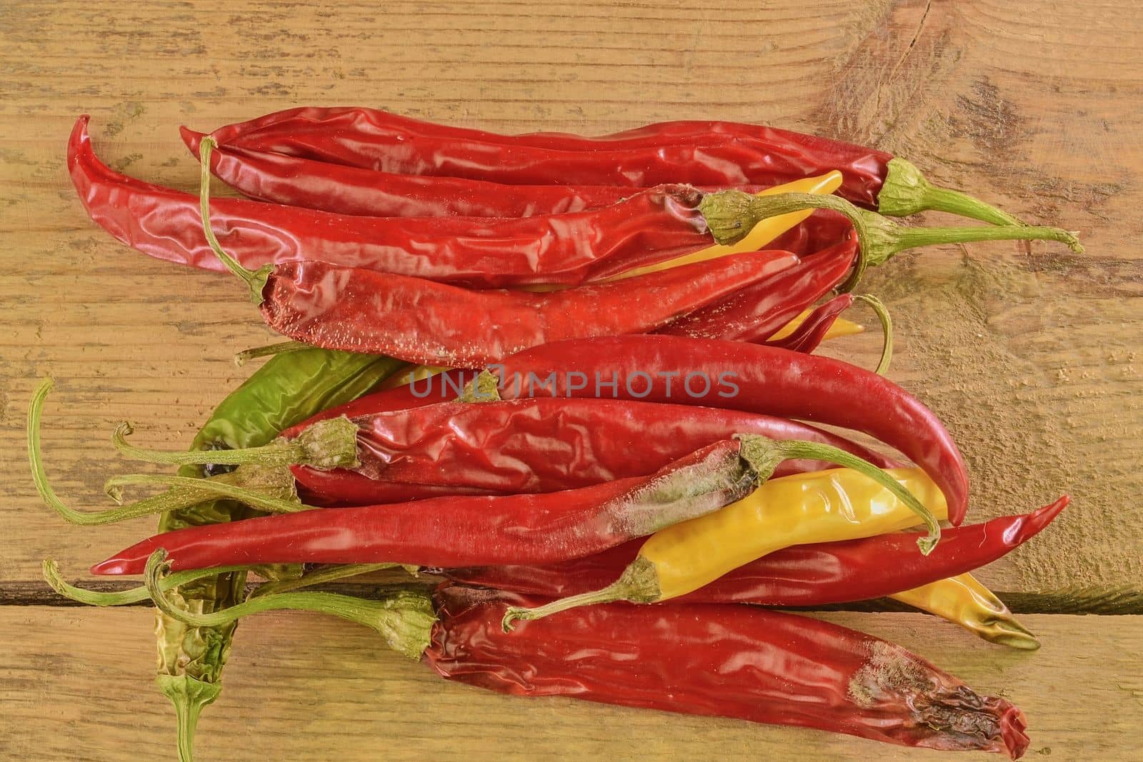 Shrinking and mould chili peppers on wooden background. Rotten chili peppers. Flat design.