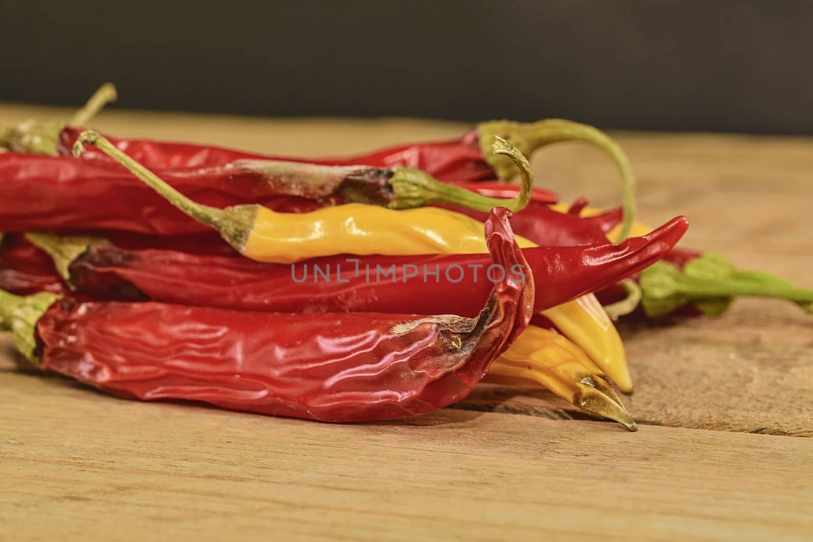 Shrinking and mould chili peppers on wooden background. Rotten chili peppers. Close-up by roman_nerud
