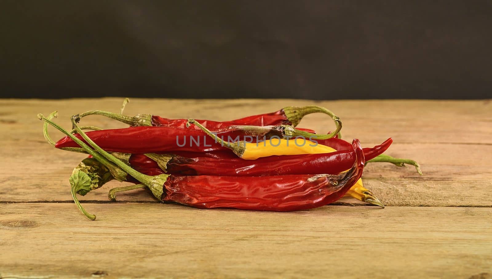Shrinking and mould chili peppers on wooden background. Rotten chili peppers. Close-up by roman_nerud