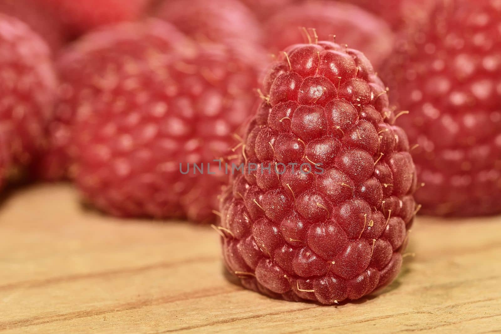 Red-fruited raspberries on wooden background. Raspberries background. Close-up by roman_nerud