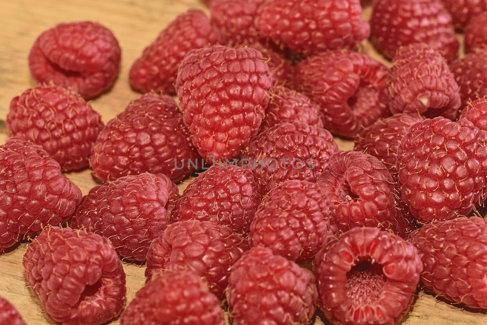 Red-fruited raspberries on wooden background. Raspberries background. Close-up.