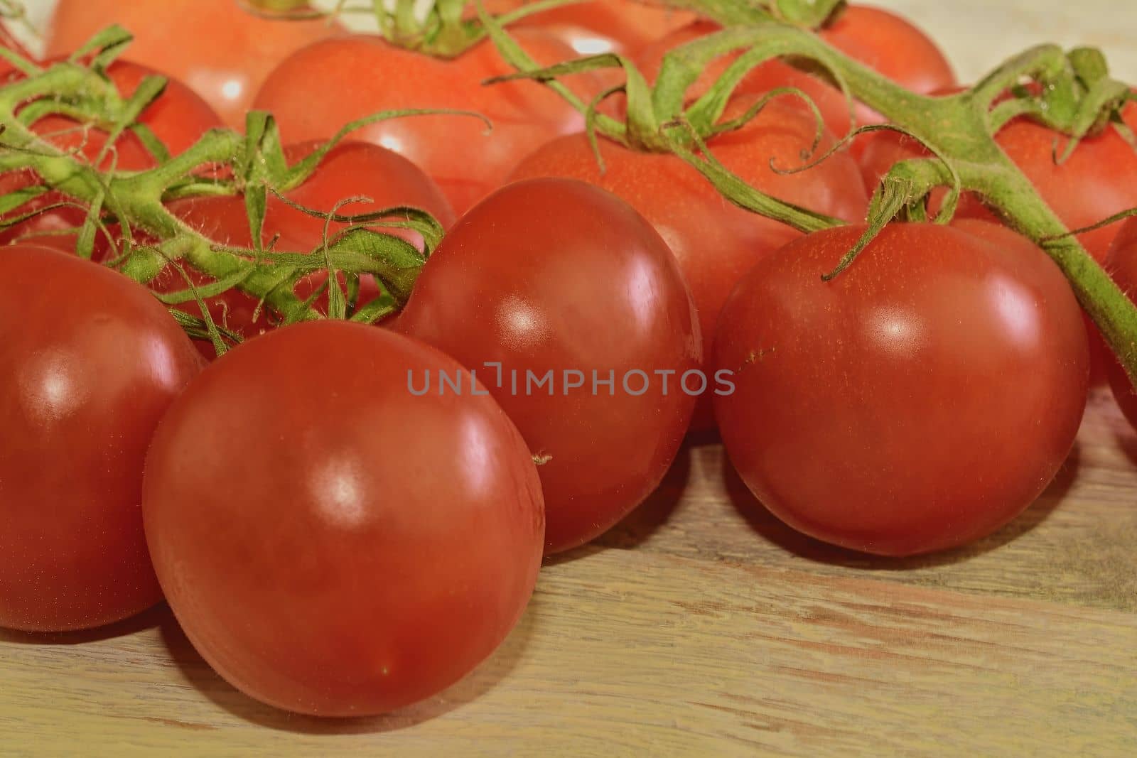 Fresh cherry tomatoes on rustic wooden background. White background. 