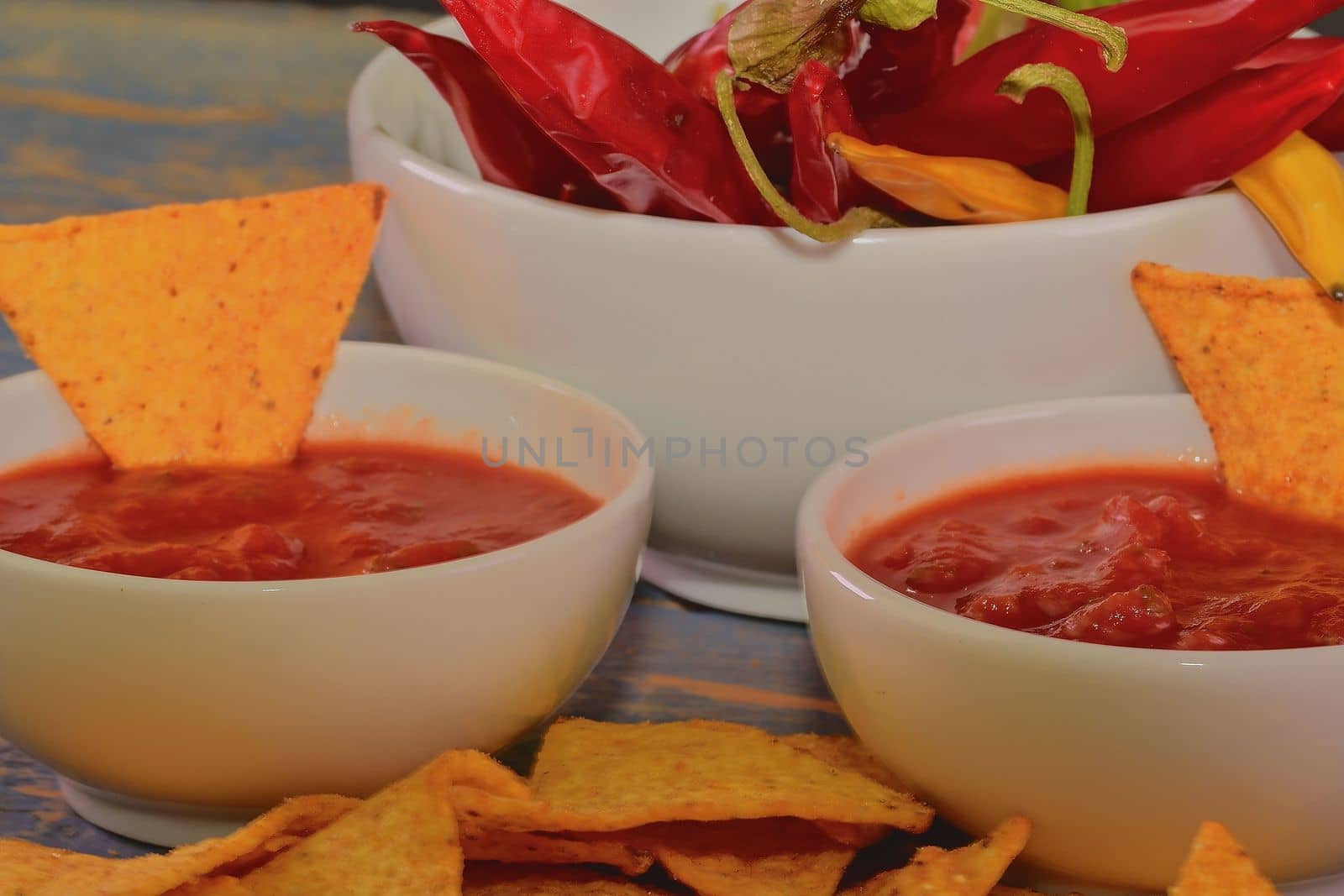 Chili corn-chips with salsa dip and chili peppers on wooden background by roman_nerud