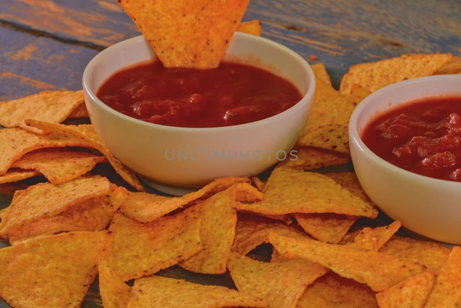 Chili corn-chips with salsa dip on wooden background. 