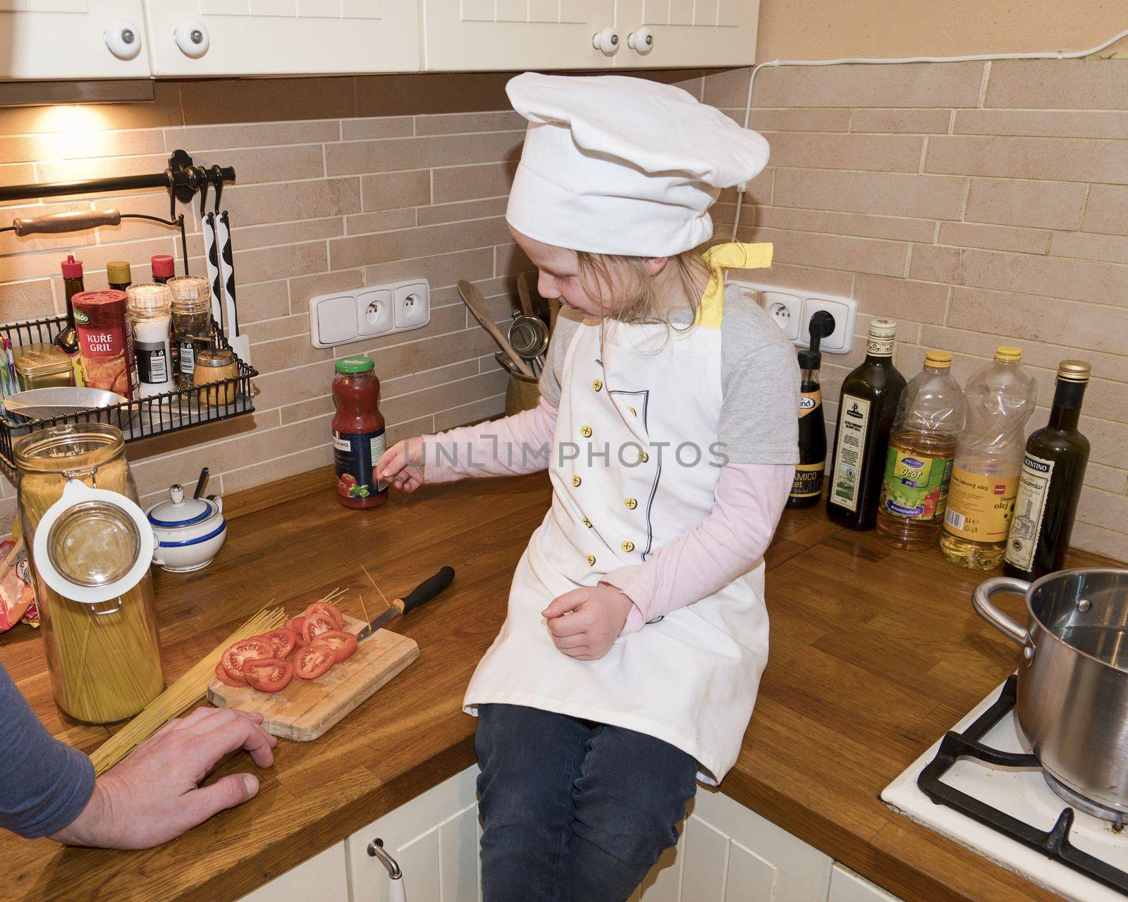 Daughter and father in the kitchen preparing spaghetti to dinner.