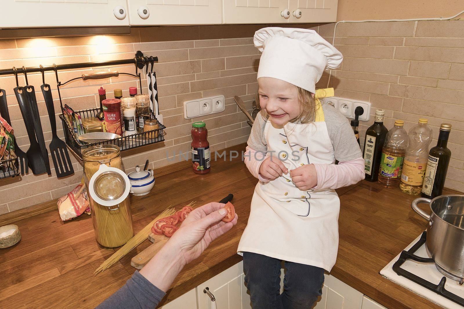 Daughter and father in the kitchen preparing spaghetti to dinner.