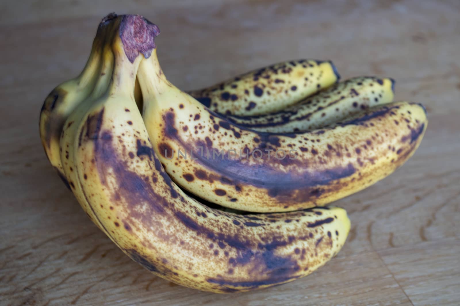 Bunch of ripe bananas on wooden background.