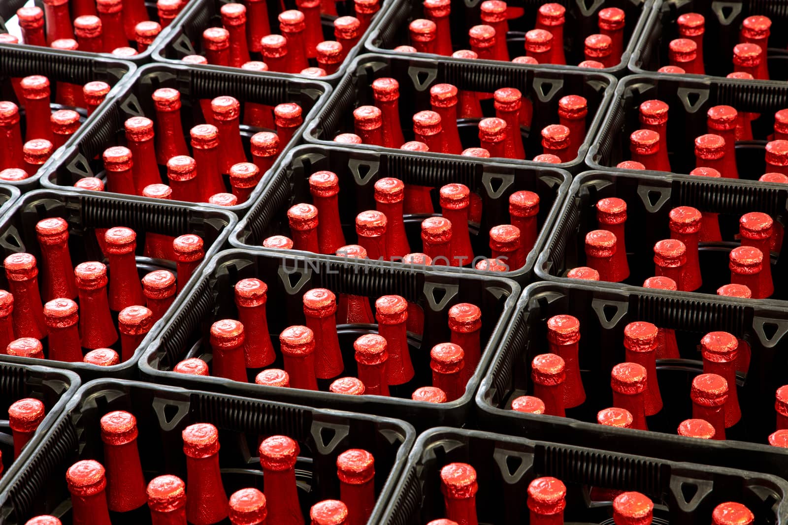 A group of red bottles in beer crates