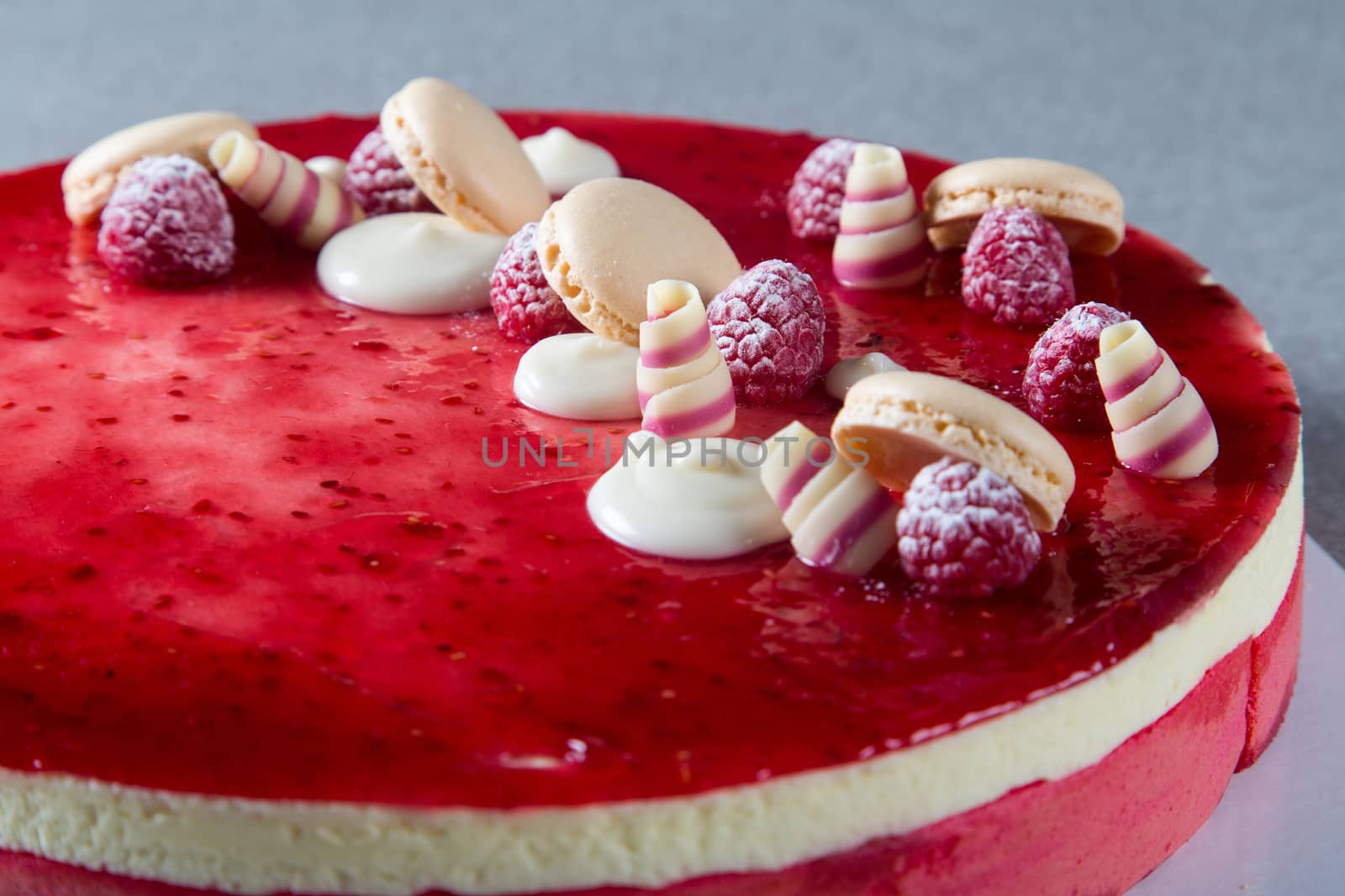 Decoration with raspberries, chocolates and biscuits on a cake