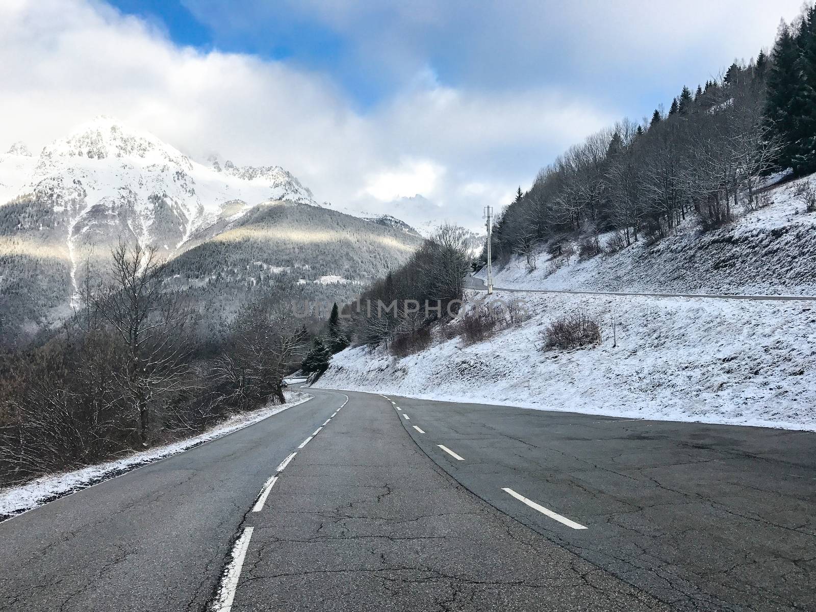 Long road travelling up in the mountains during winter