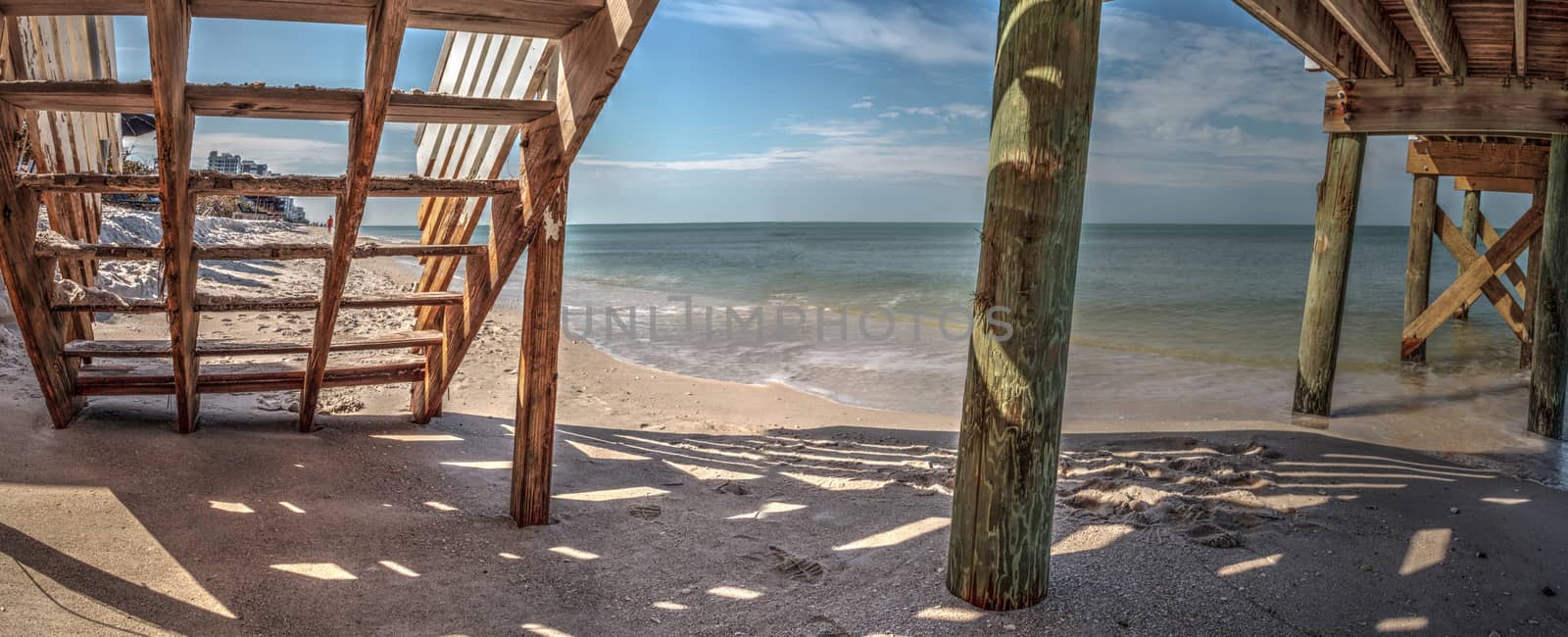 Boardwalk across the White sand beach and aqua blue water of Clam Pass in Naples, Florida in the morning. 