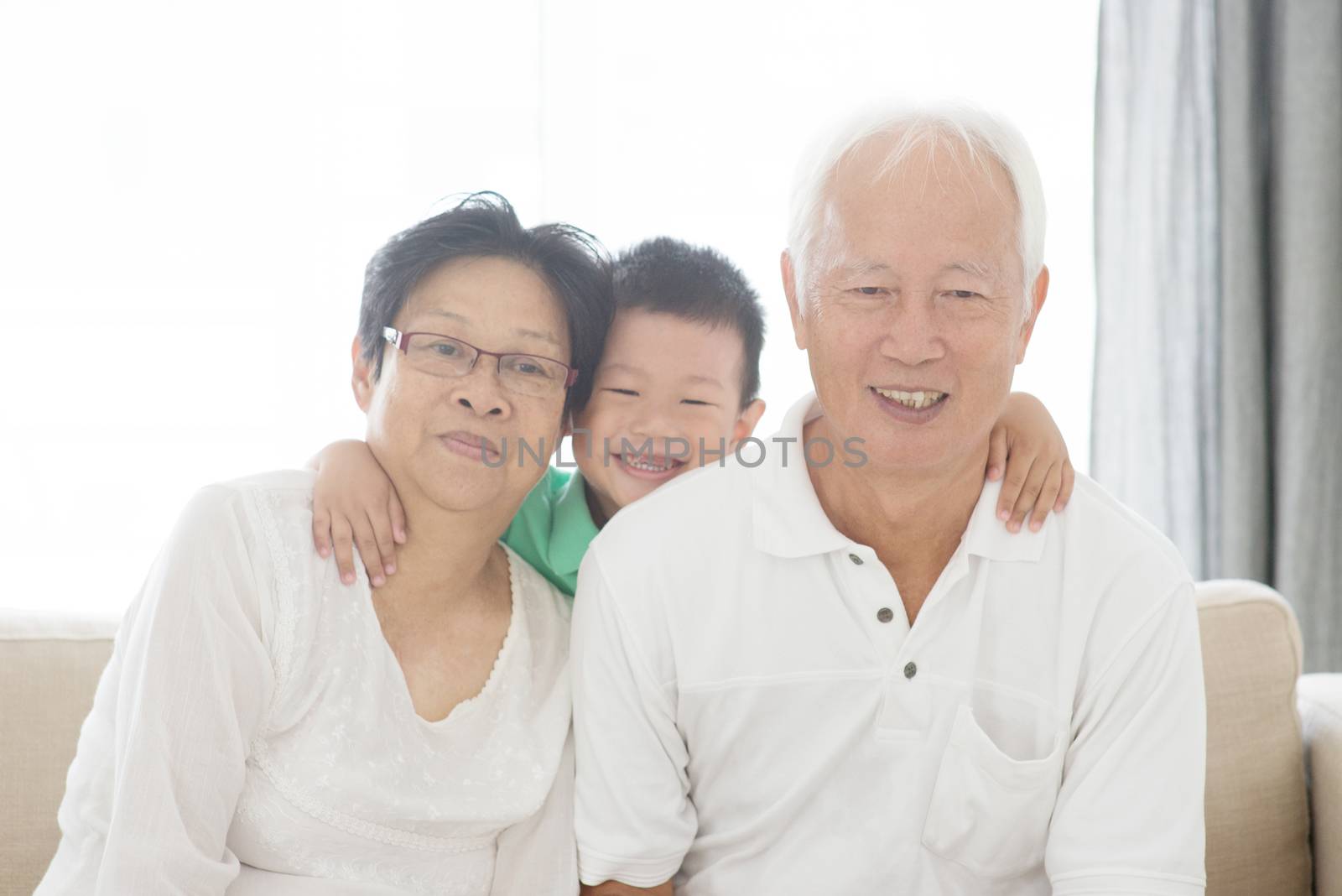 Portrait of Asian grandparents and grandchild at home, old senior retired people indoor lifestyle.
