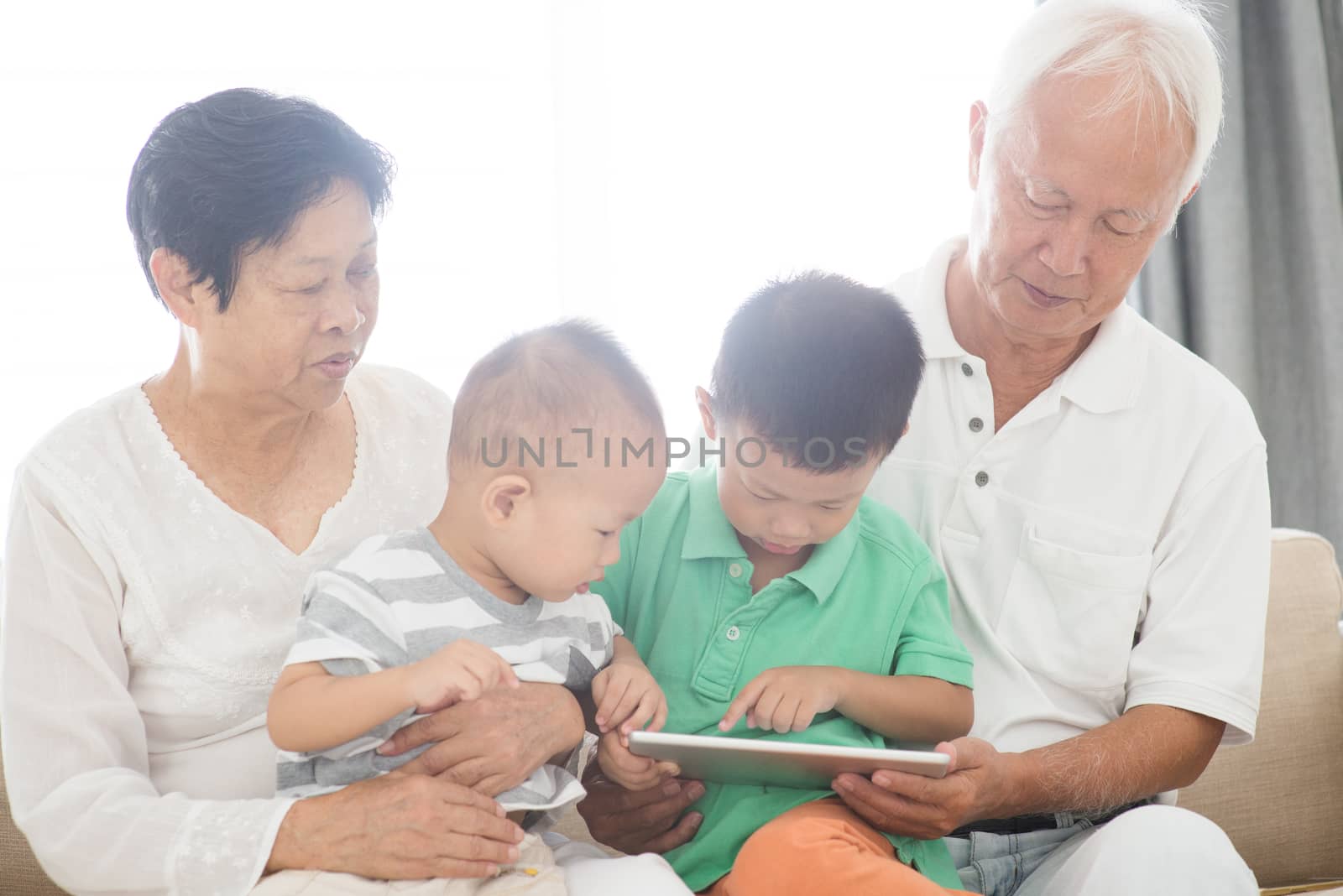 Grandparents and grandchildren using tablet pc  by szefei