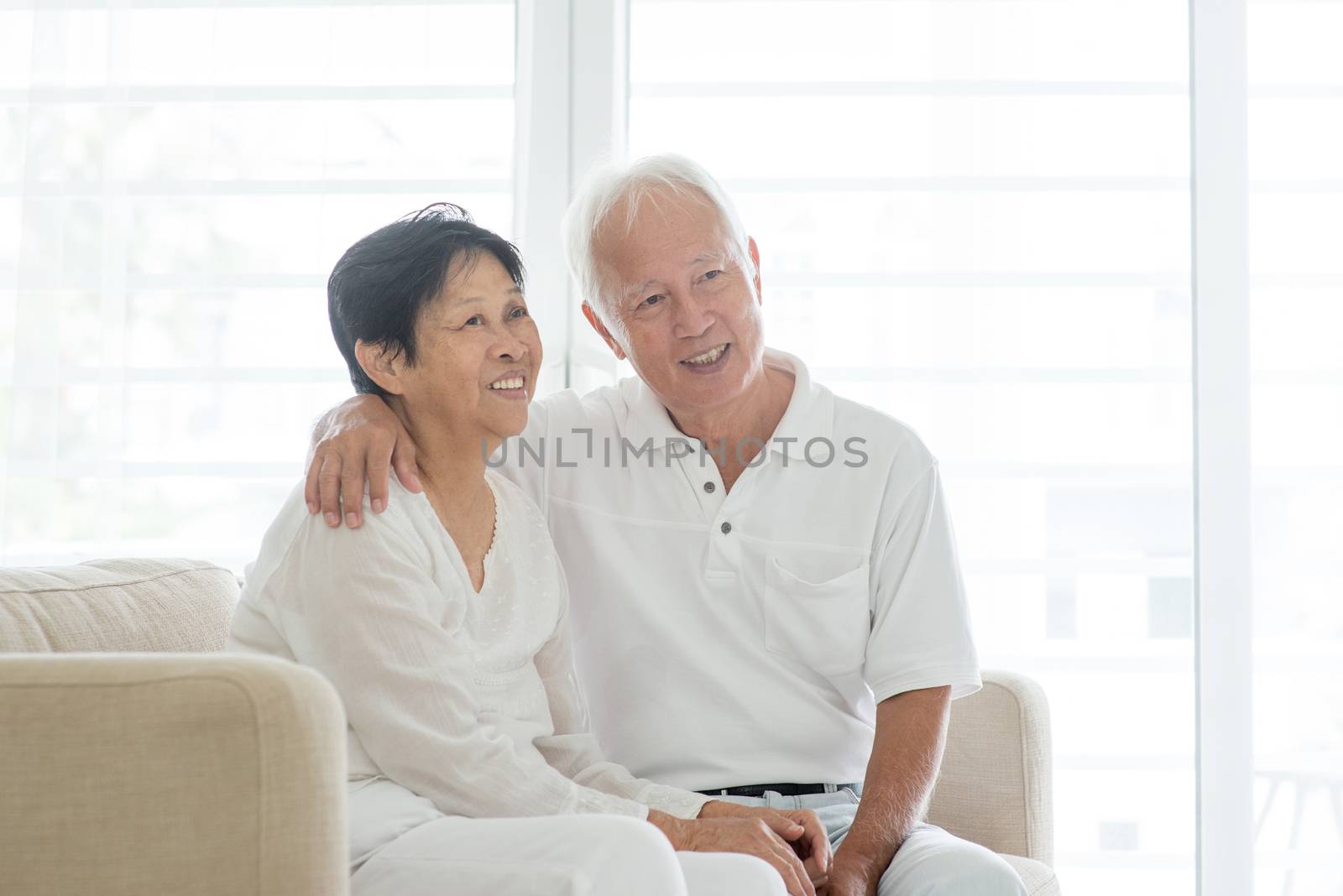 Portrait of happy Asian elderly couple at home, looking away, old senior retired people indoor lifestyle.