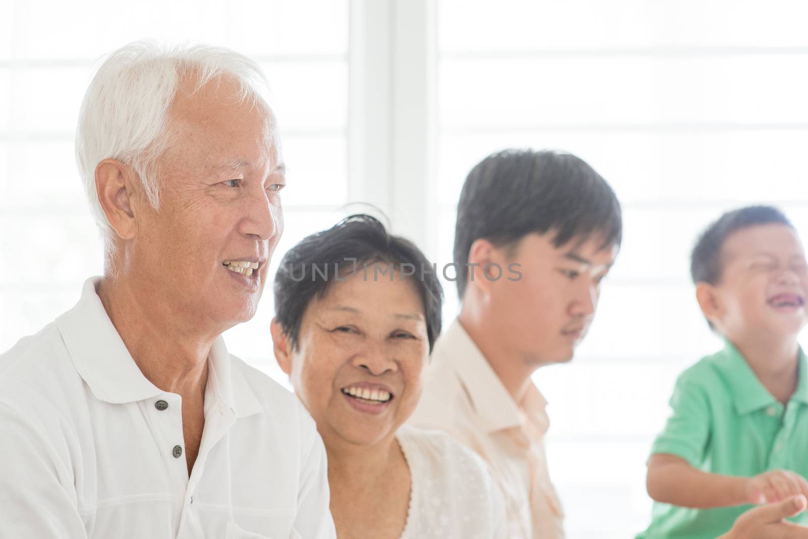 Candid of happy Asian family relaxed at home, multi generations people indoor lifestyle.