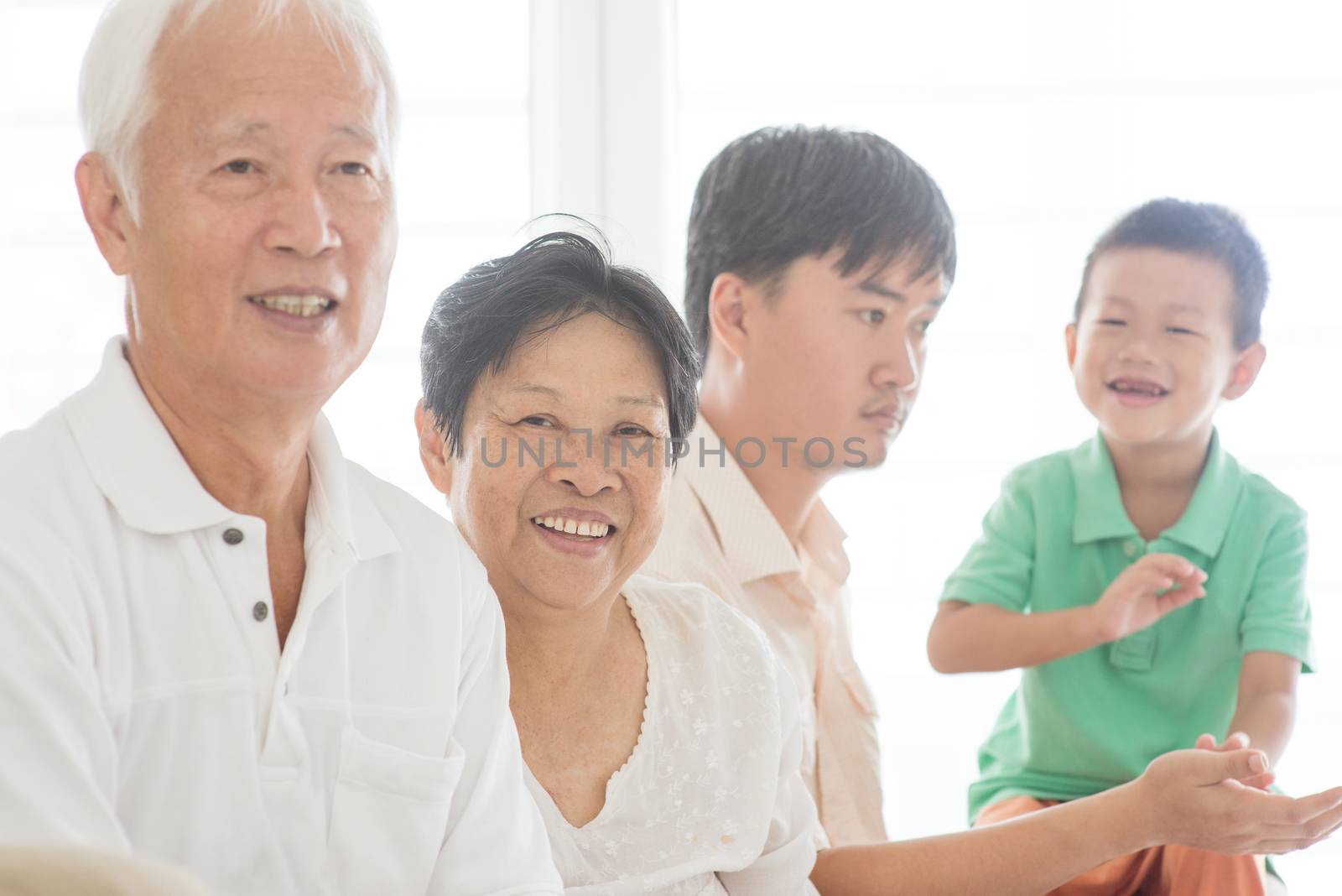 Candid of happy Asian family relaxing at home, multi generations people indoor lifestyle.
