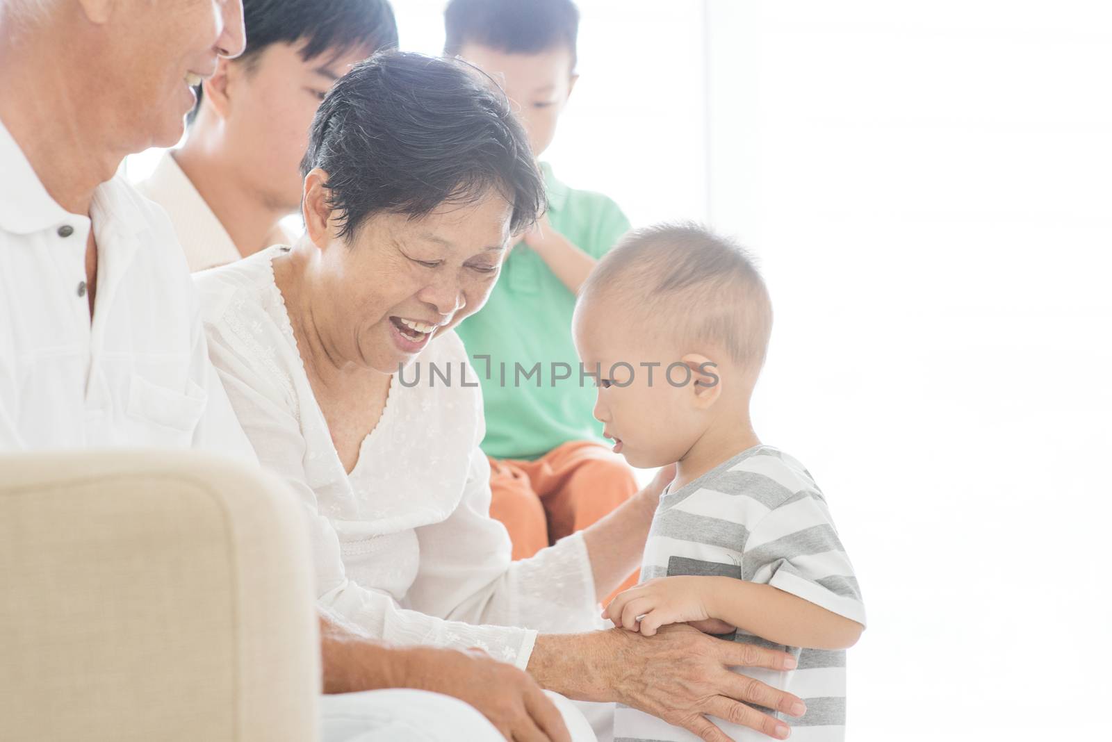 Happy Asian family relaxing at home, candid moment of multi generations people indoor lifestyle.