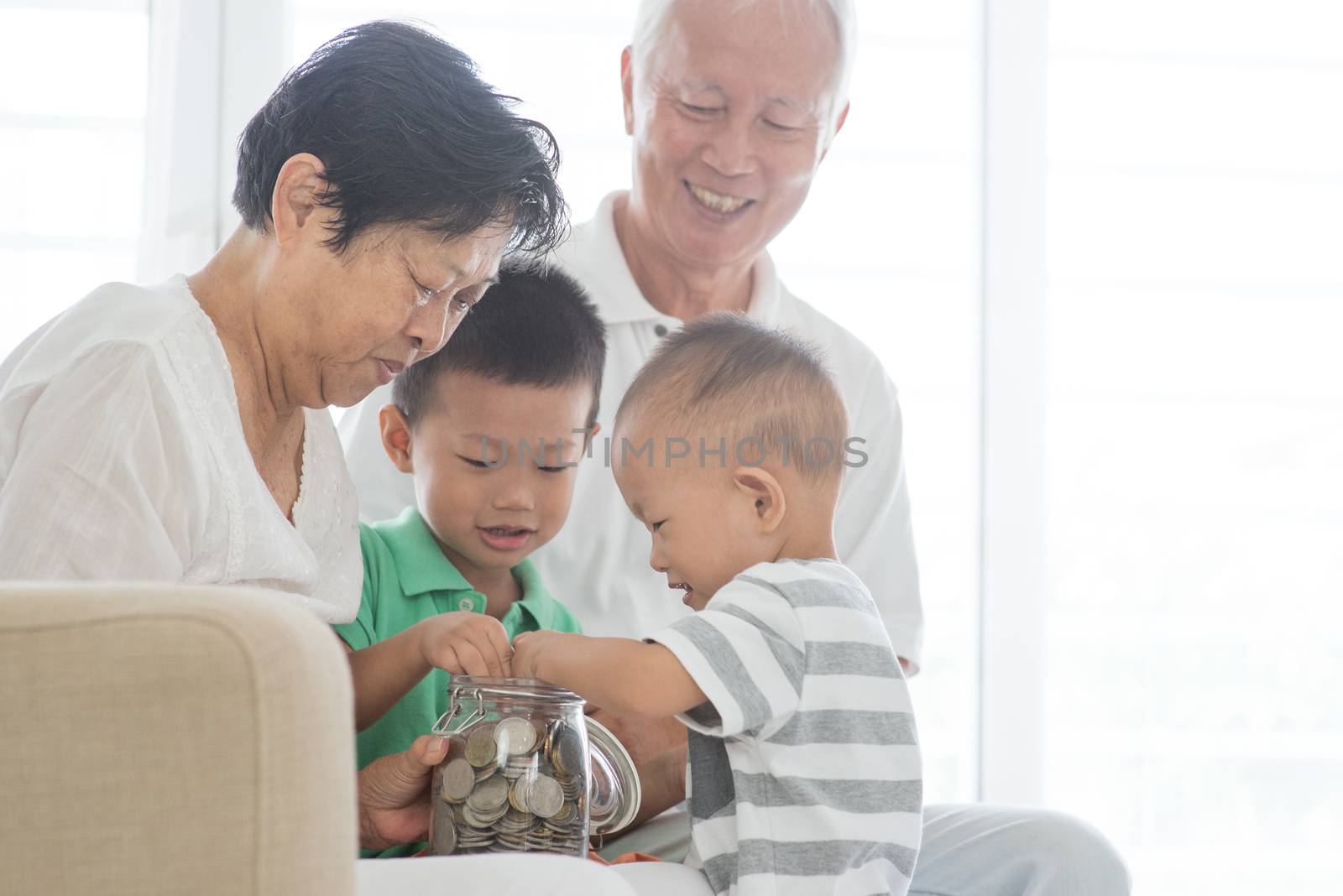 Asian elderly and children saving money at home. Family financial planning, investment, insurance, retirement, senior and junior banking concept. 