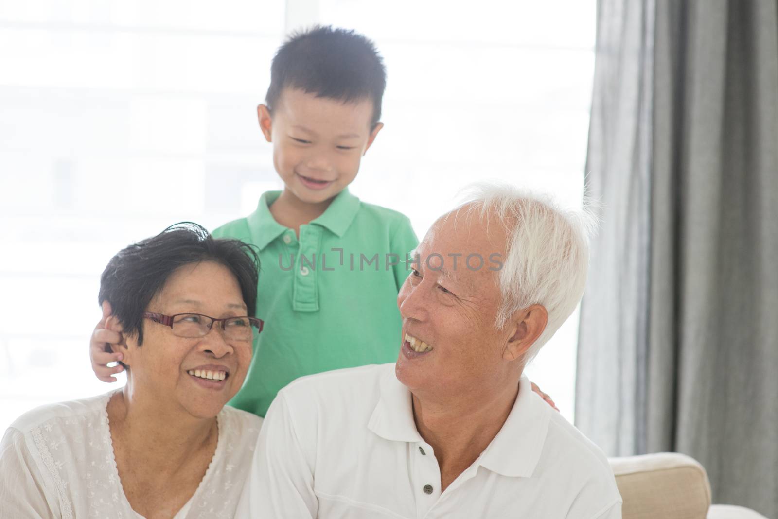Portrait of happy Asian grandparents and grandson at home, old senior retired people and child indoor lifestyle.