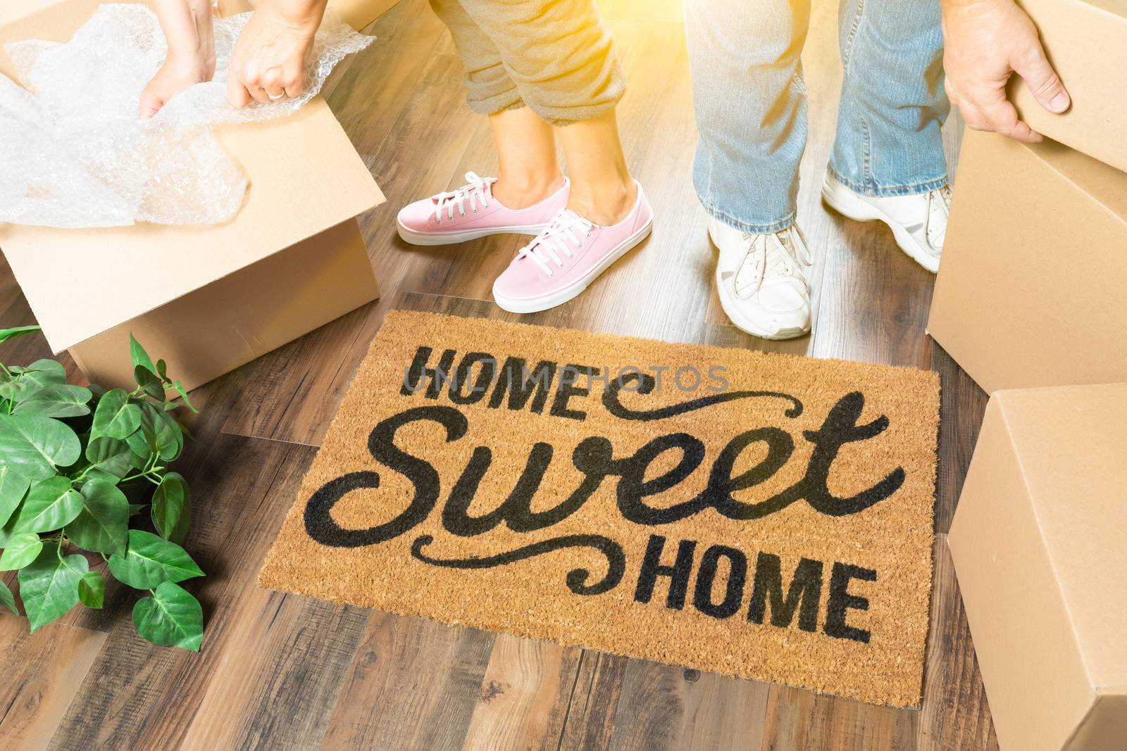 Man and Woman Unpacking Near Home Sweet Home Welcome Mat, Moving by Feverpitched