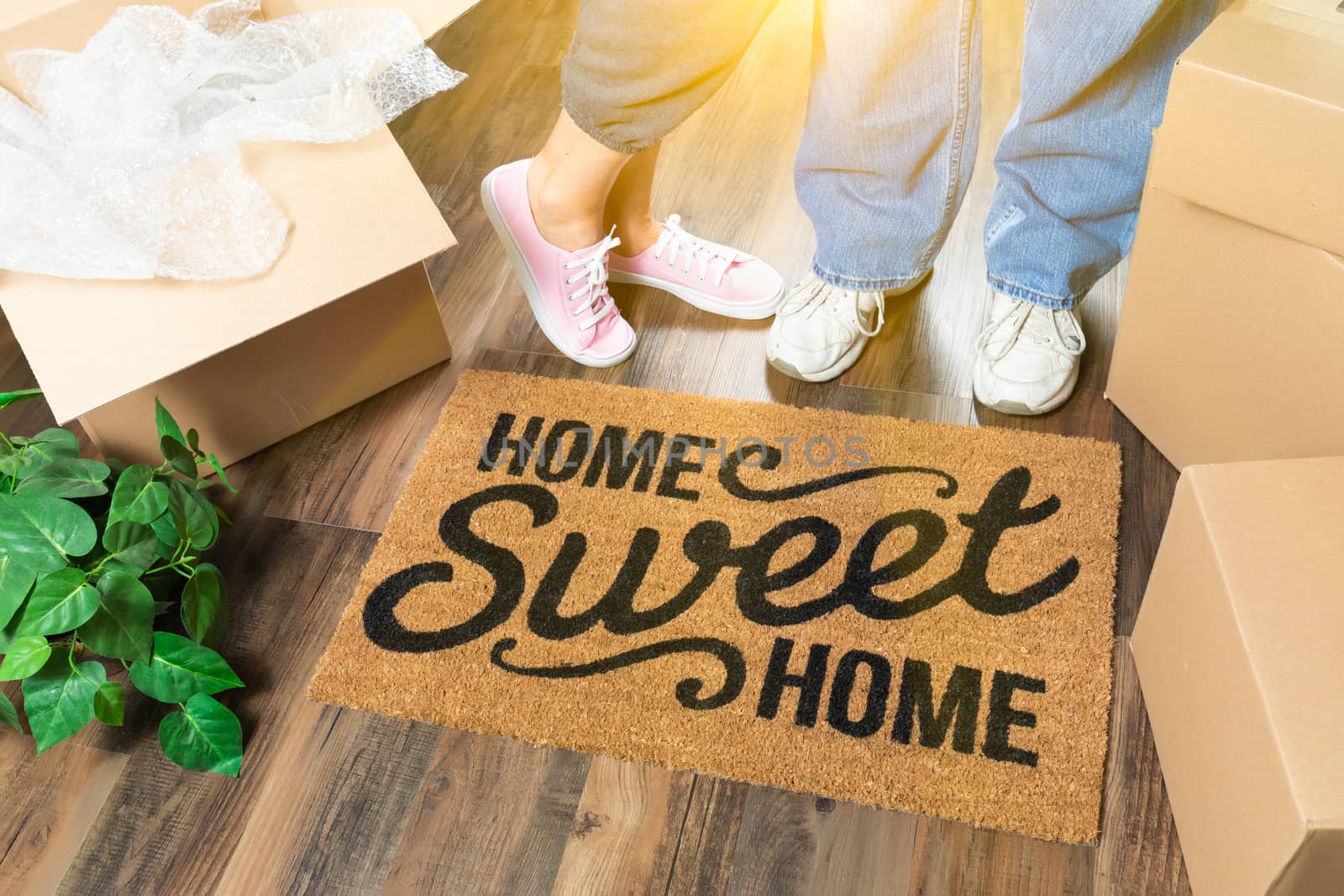 Man and Woman Standing Near Home Sweet Home Welcome Mat, Moving  by Feverpitched