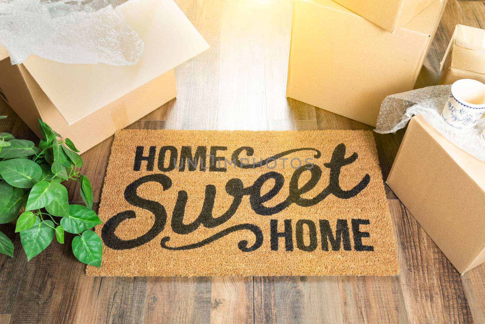 Home Sweet Home Welcome Mat and Moving Boxes on Hard Wood Floor by Feverpitched