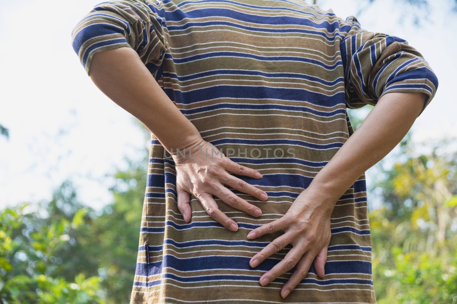 A man suffering from backache, spinal injury and muscle issue problem at outdoor.