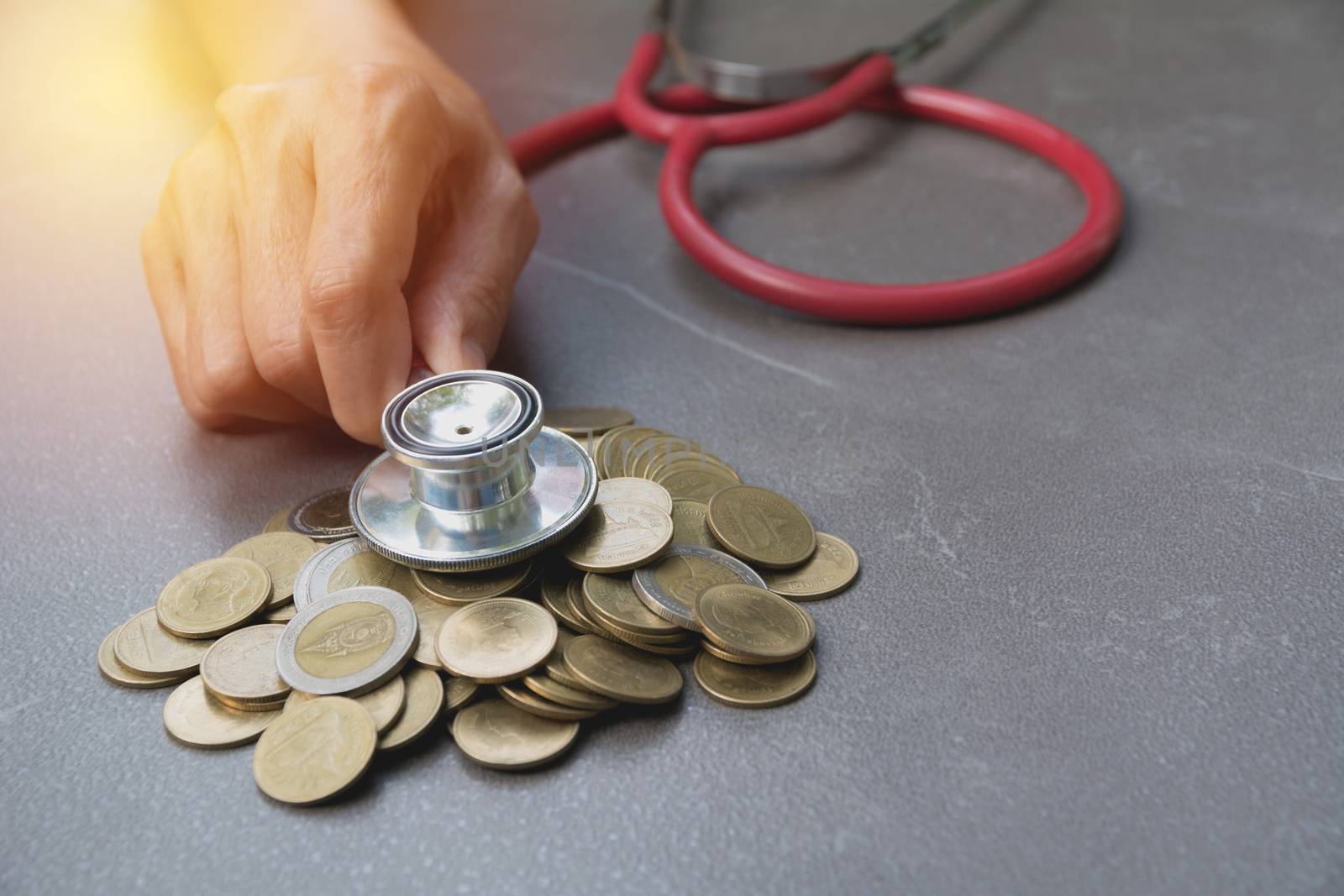 Stethoscope with Coins in jar with money stack, Concept finance, accounting, business and saving investment.