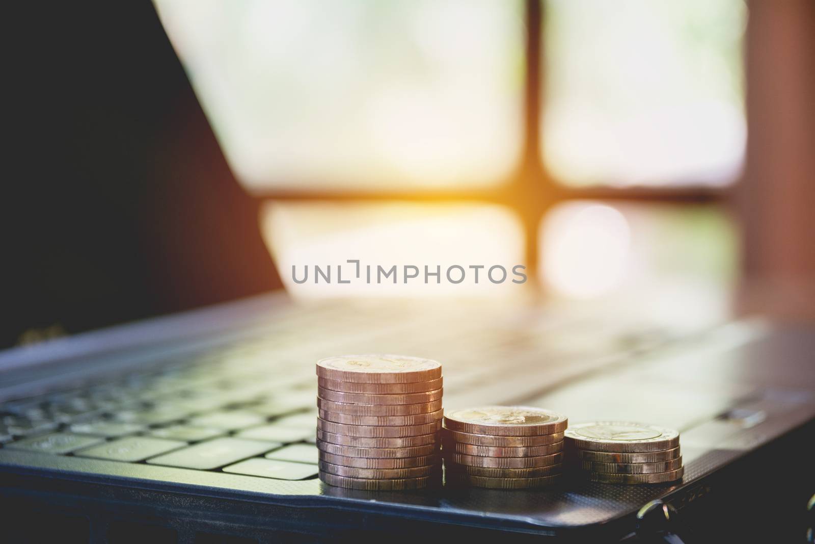 Stack coins on laptop. Financial, accounting and saving concept.
