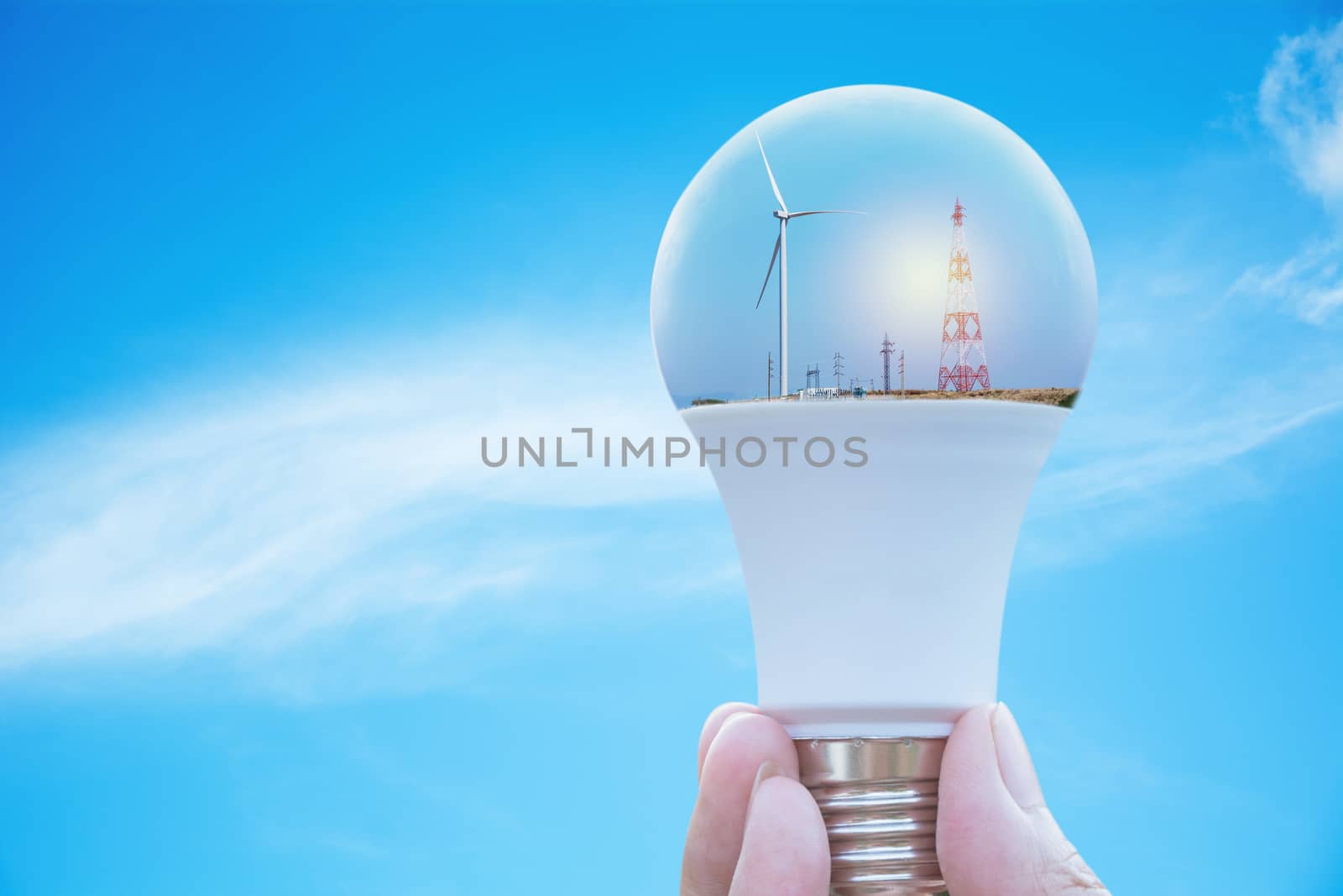 Hand of person holding light bulb for idea or success or solar energy concept.