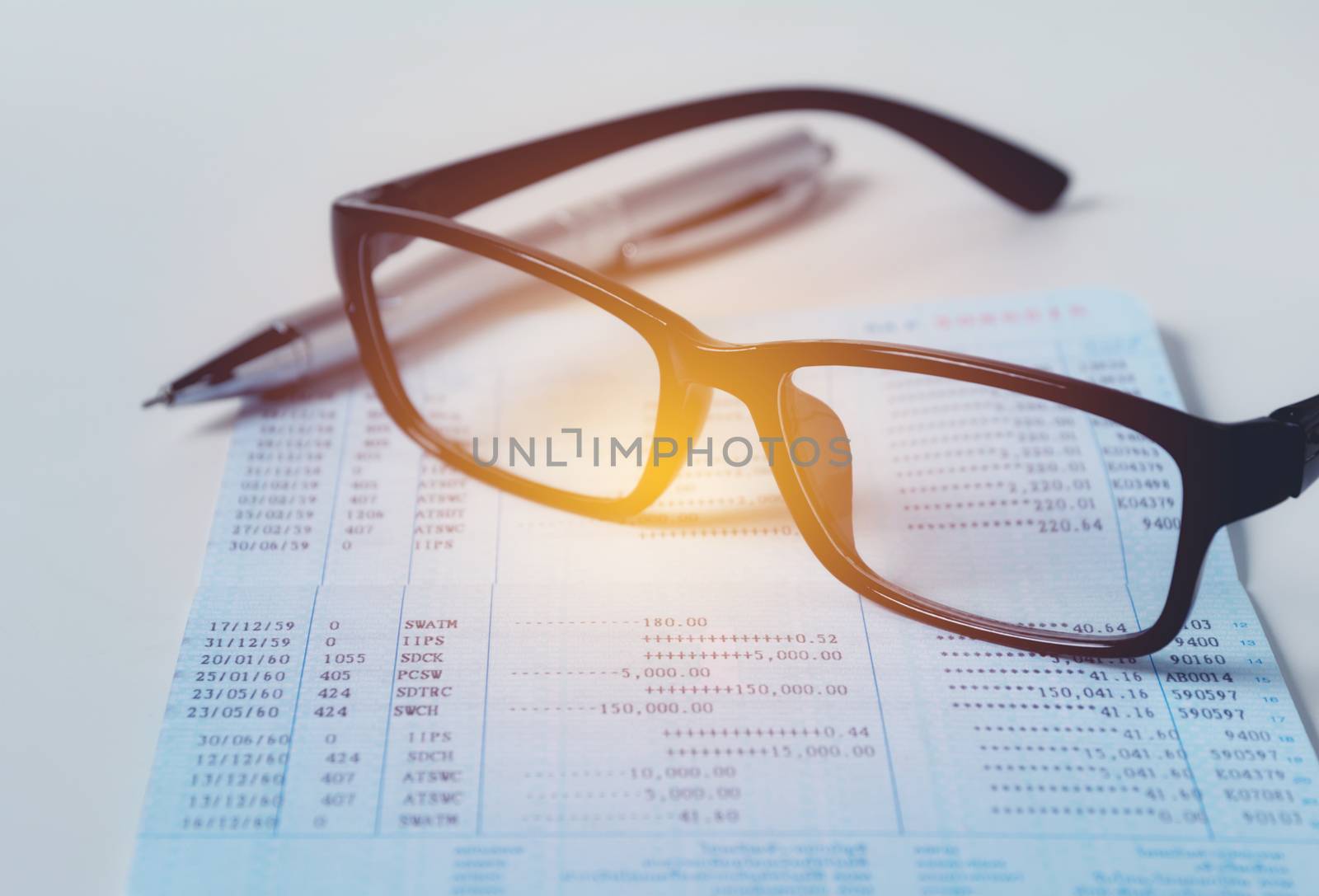 Glasses with bank account passbook for savings financial and accounting concept.