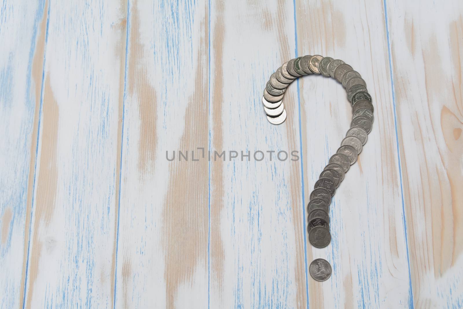 Saving money concept and money coin shape question mark  on wooden table for business.