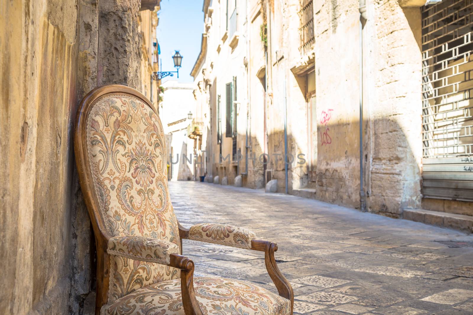 Lecce town, Italy. Vintage chair with old town street in background.