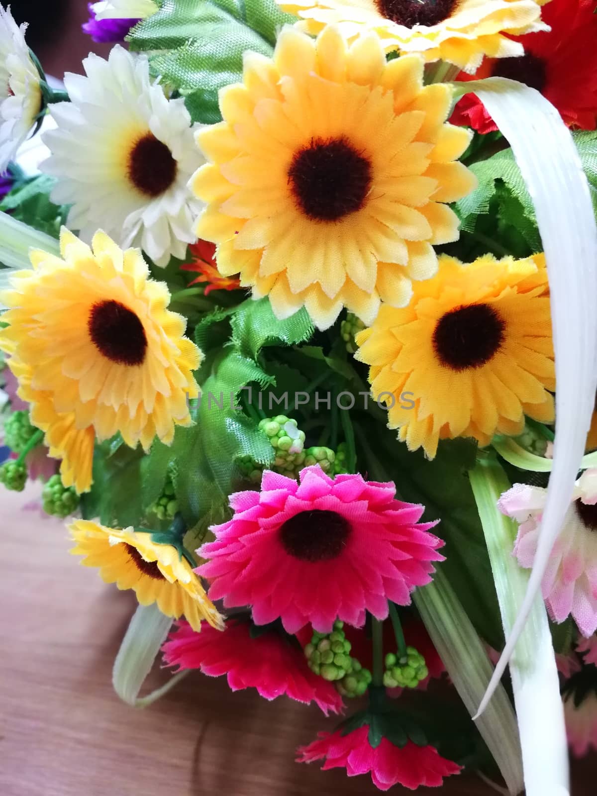 multi color of plastic flowers for decorations on office table by shatchaya
