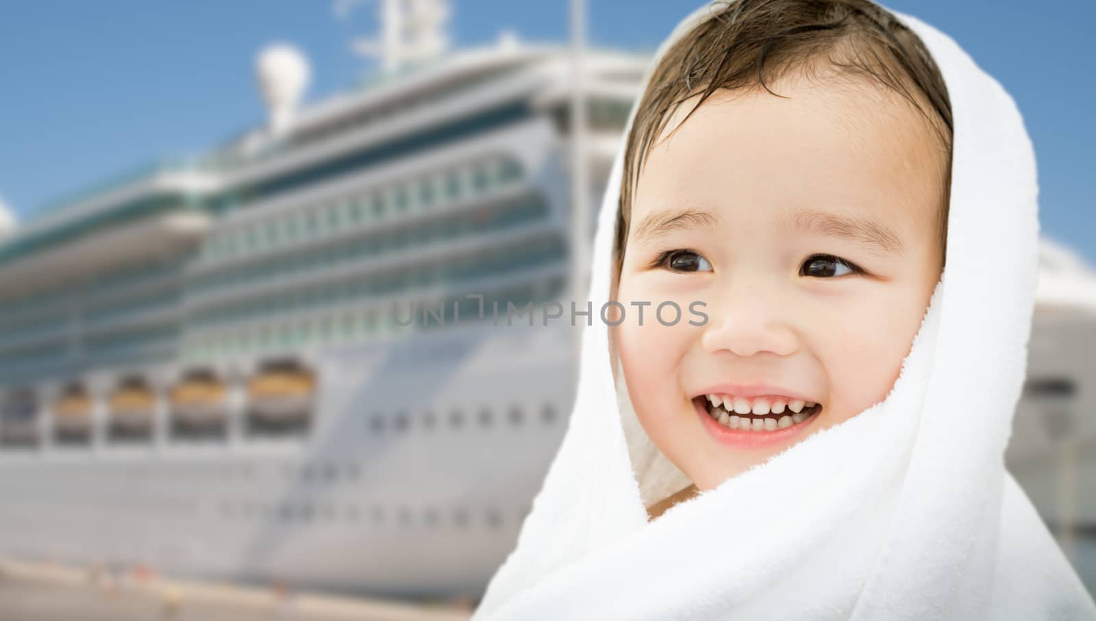 Happy Mixed Race Chinese and Caucasian Boy Near Cruise Ship Wrapped In A Towel.