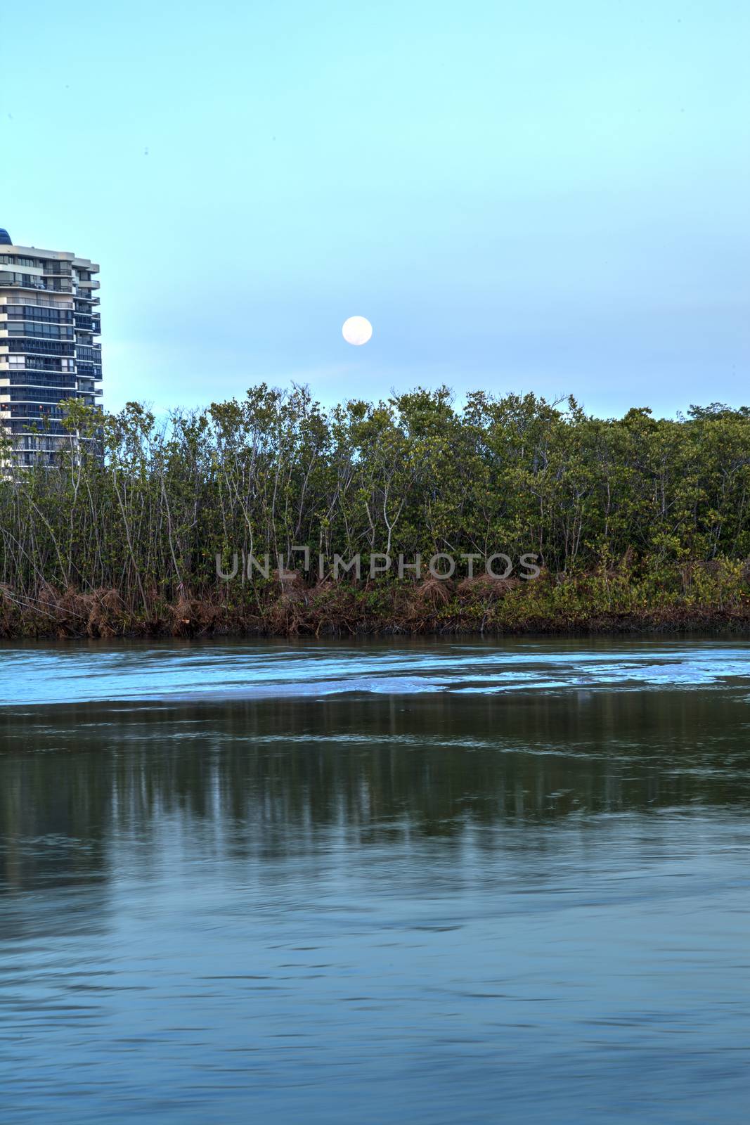 Moonrise over River leading to the ocean at Clam Pass at dusk in Naples, Florida