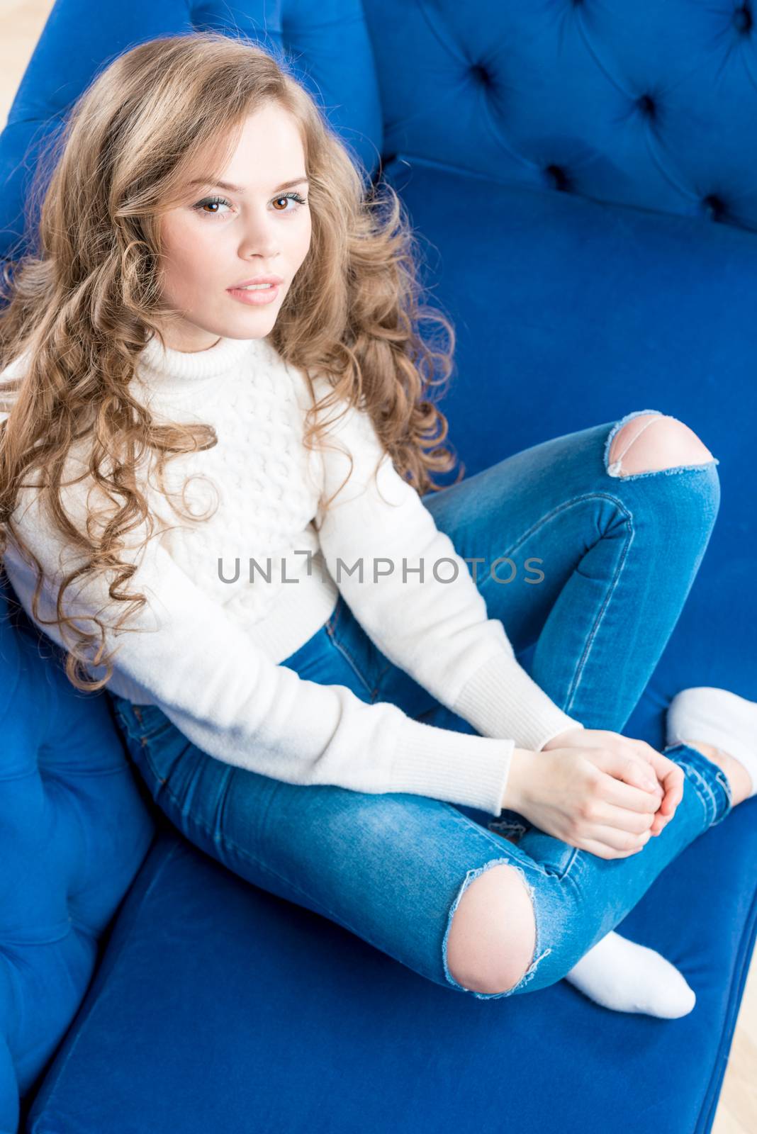 top view of a beautiful girl in a warm sweater on the sofa in the living room