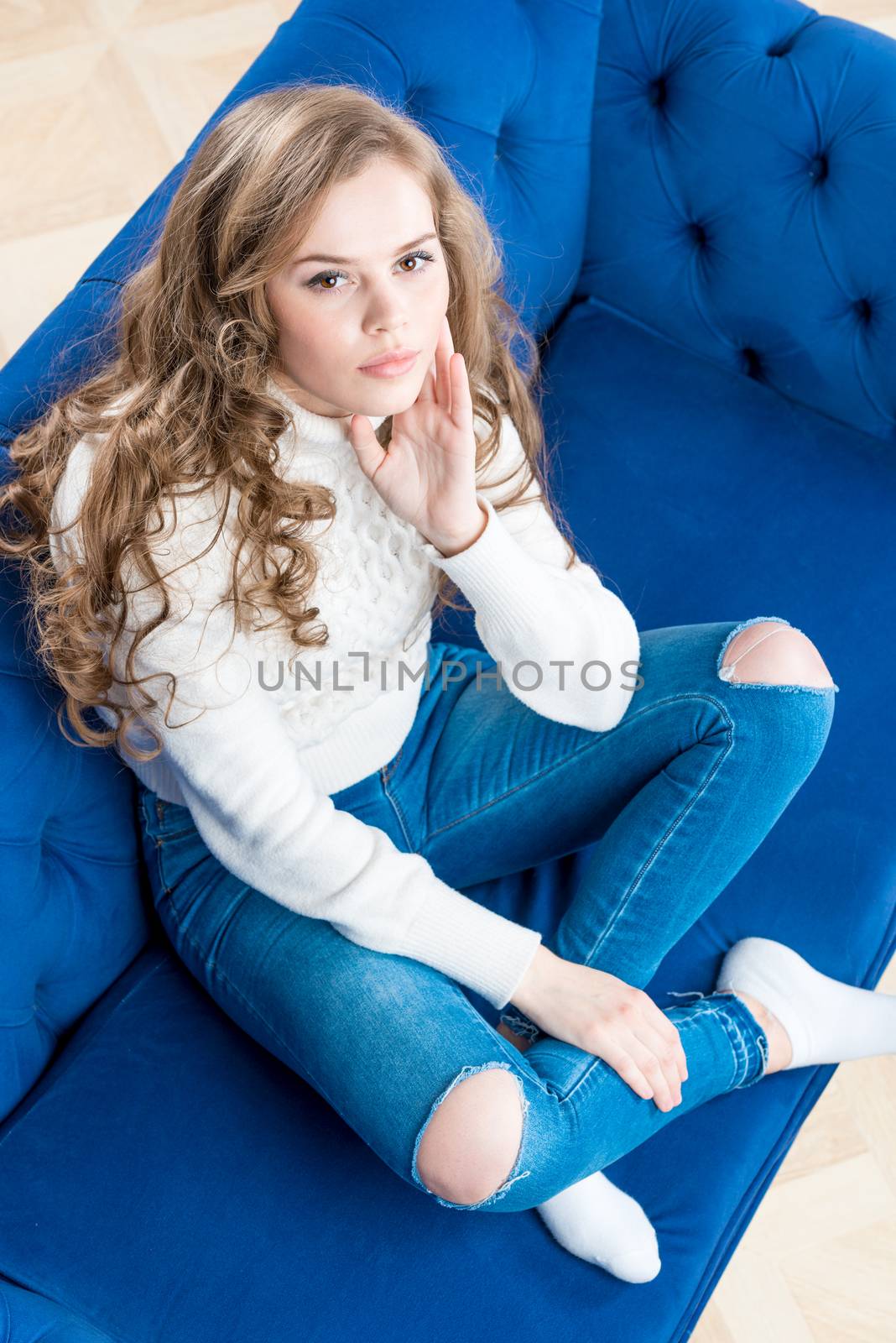 cute girl in a warm sweater on the couch in the living room view from above