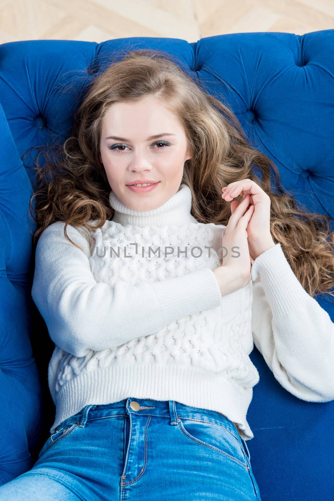 woman with beautiful smile posing on couch in living room in swe by kosmsos111