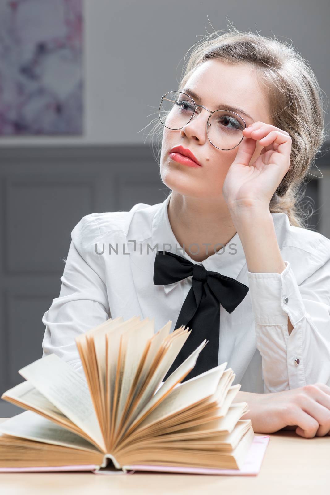 portrait of a dreamy young woman in stylish glasses with a book by kosmsos111