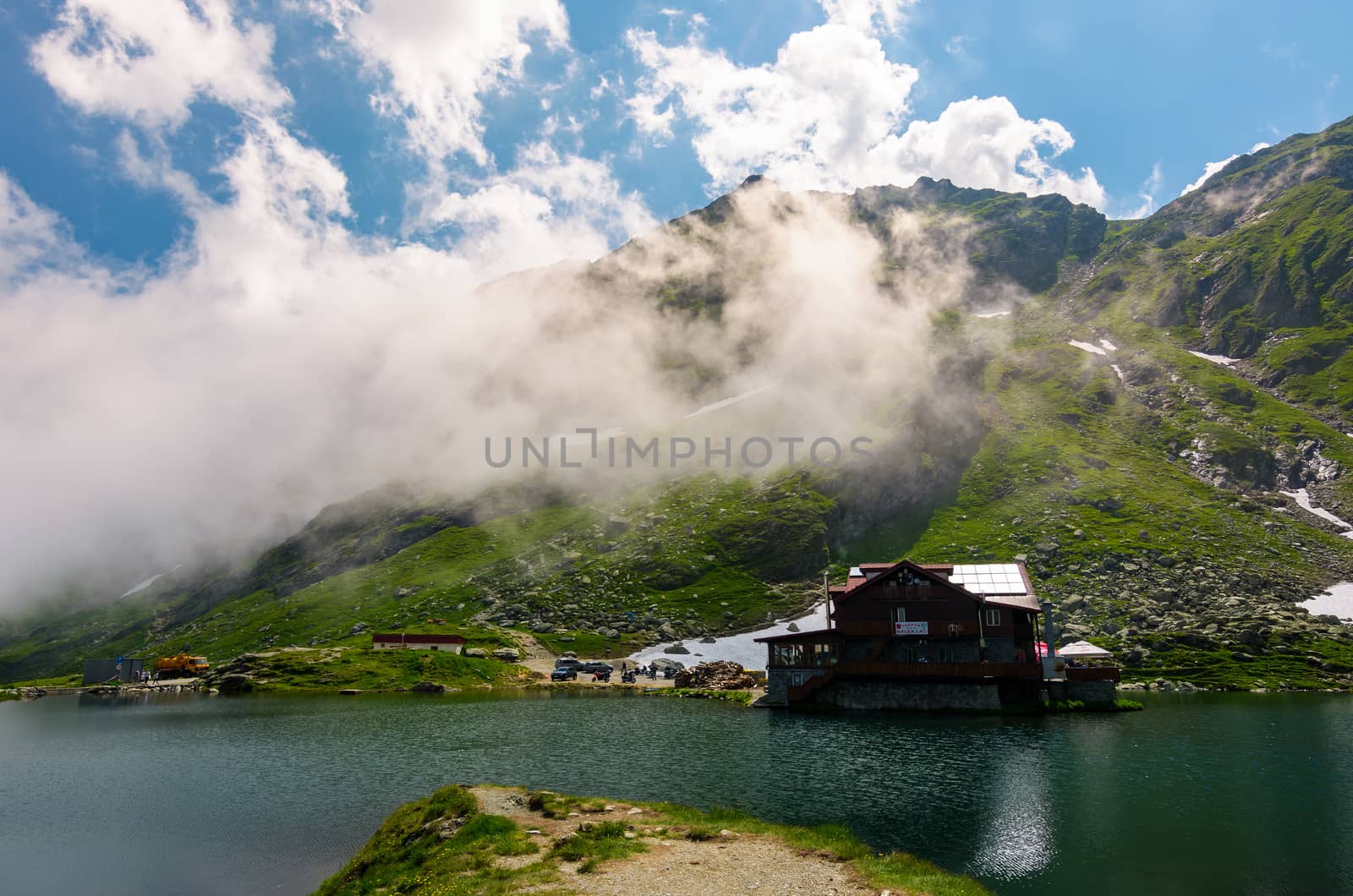 lake Balea of Fagaras mountains. lovely summer landscape with low clouds around the peak