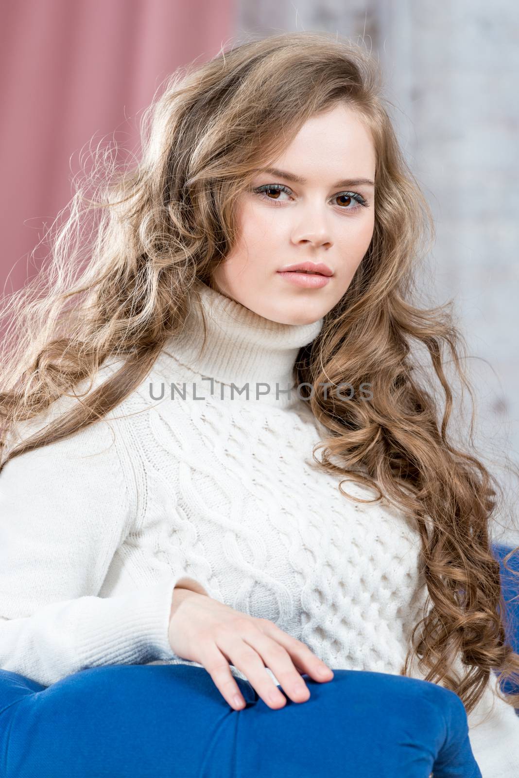 beautiful woman with long curly curls posing indoors