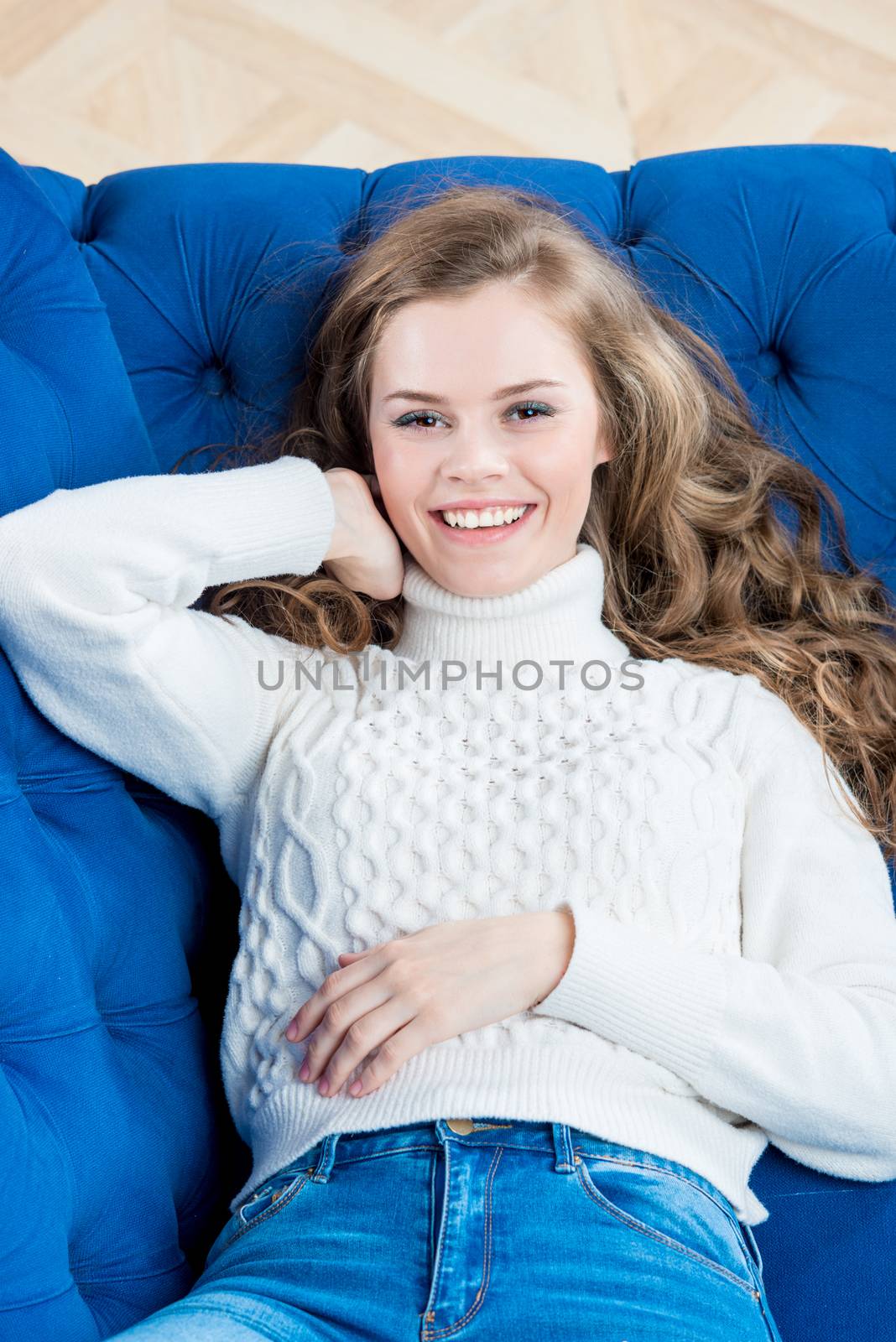 beautiful woman with long hair lies on sofa in living room by kosmsos111