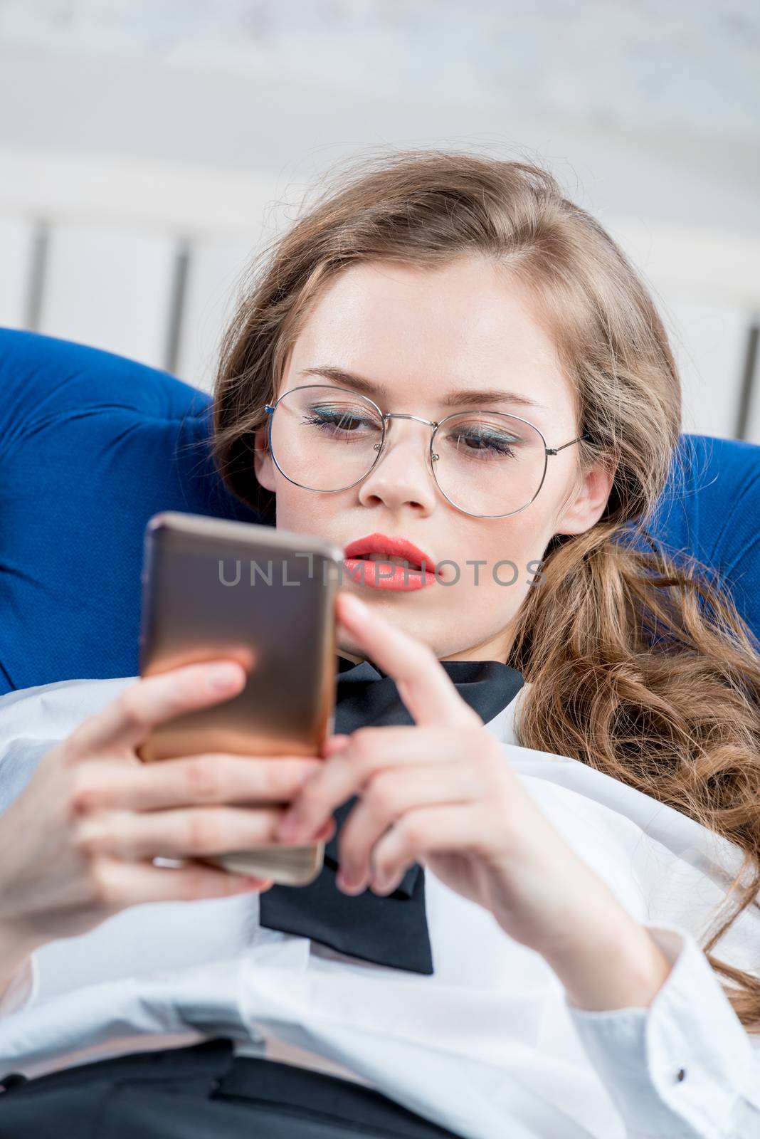 beautiful young woman with a phone on the couch