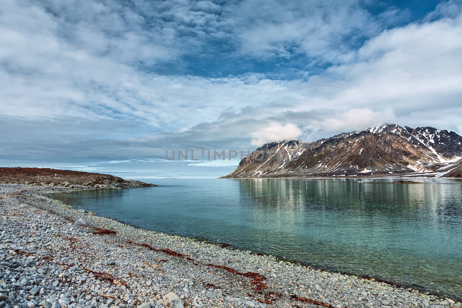 Cloudy sky and mountains along the bank in Magdalenafjord in Svalbard islands, Norway