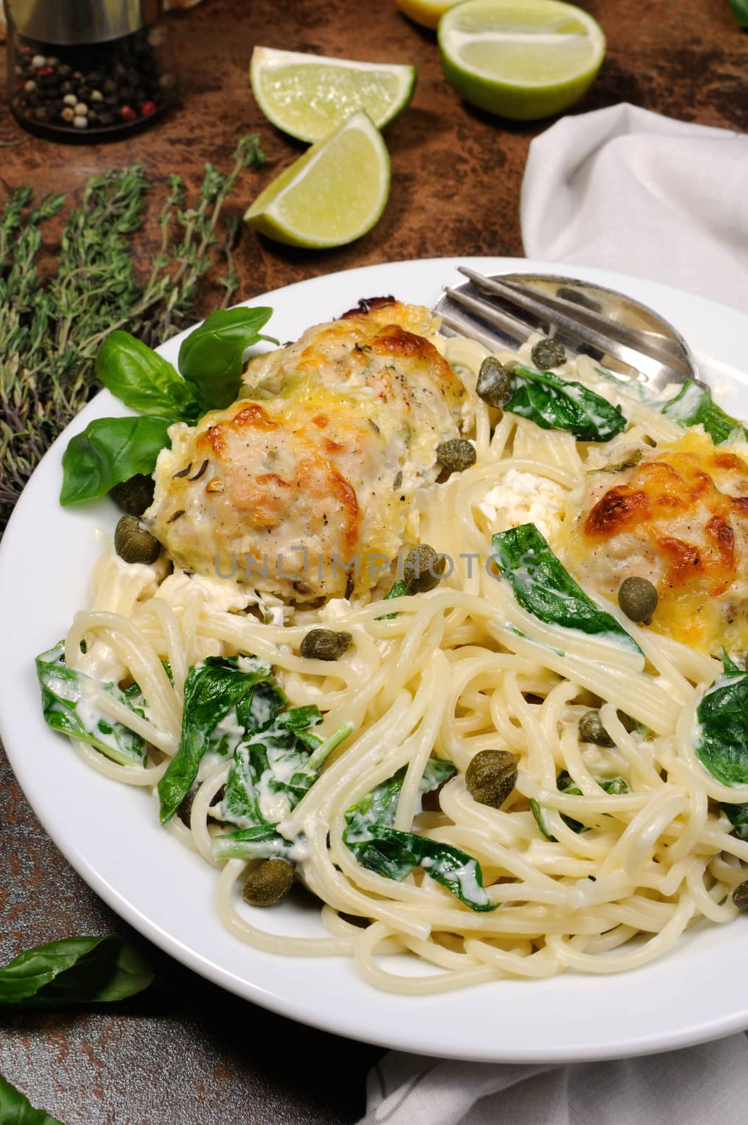 Spaghetti with chicken meatballs in cheese cream sauce , spinach and capers